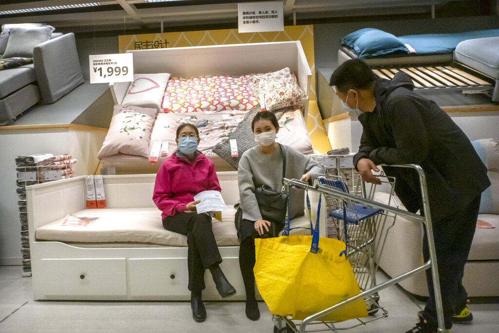 Three customers are shopping in Ikea with face masks on.