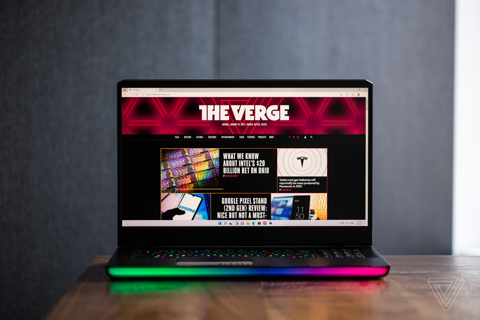 The MSI GE76 Raider seen fromn the front on a wooden table. The screen displays The Verge homepage.