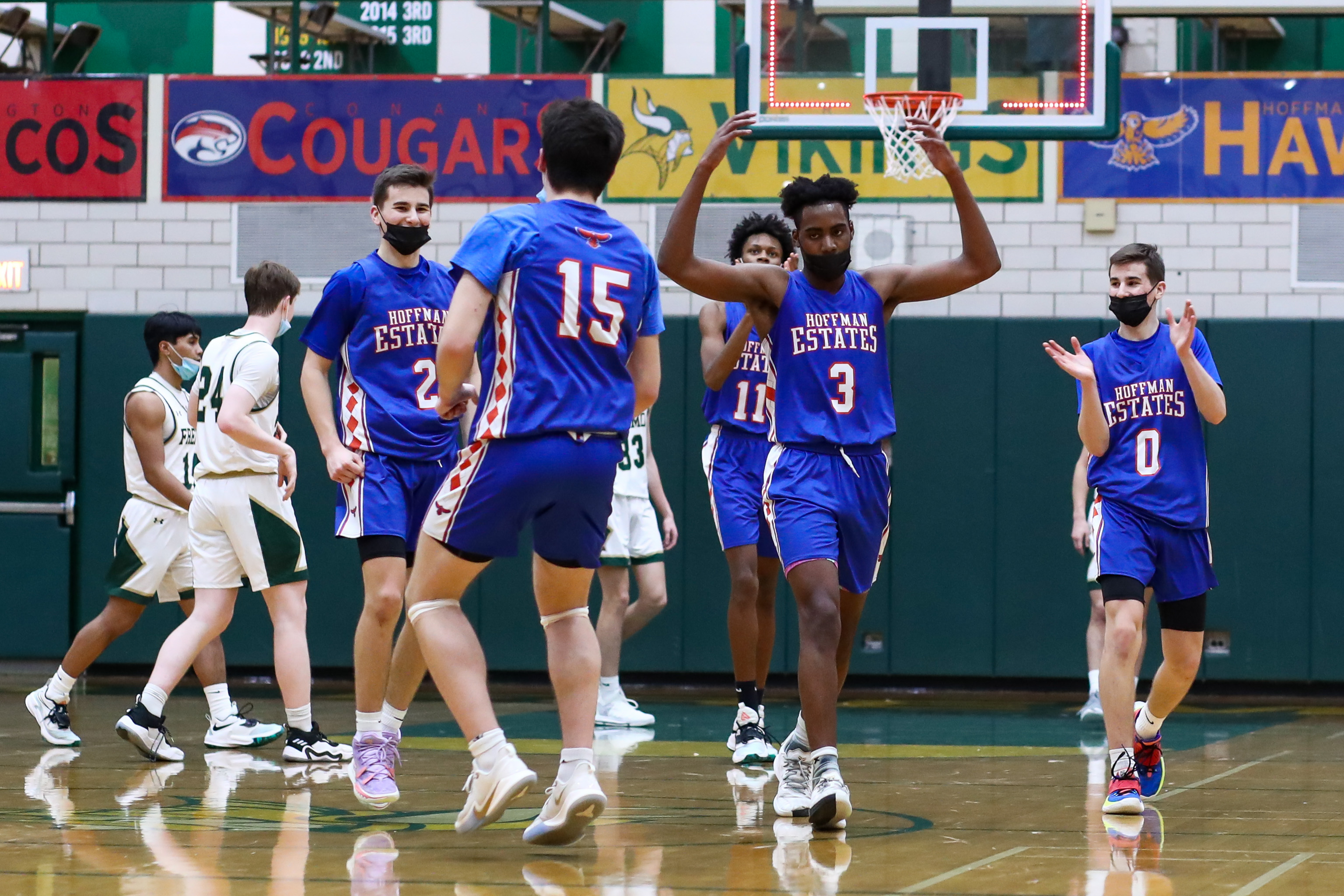 Hoffman Estates’ Darien Irvin (3), Mike Vuckovic (0) and Nick Vuckovic (2) react with teammates after winning the game against Fremd. 
