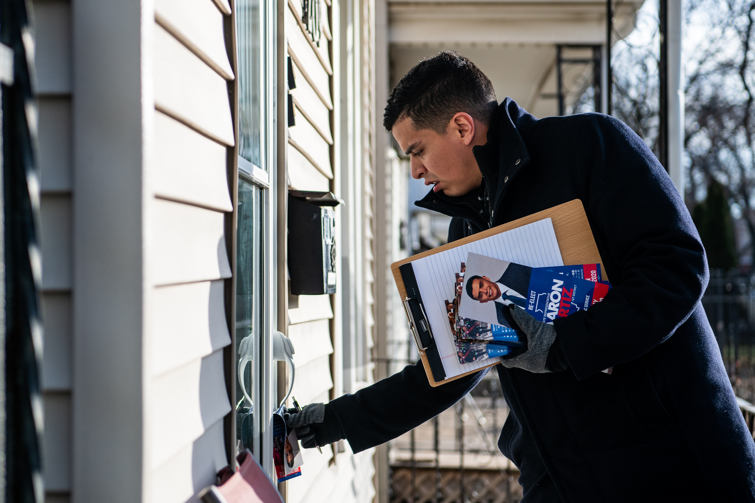 Illinois Representative Aaron Ortiz leaves a campaign flyer between the door and the frame at a home in Chicago’s 14th Ward during his canvas of the 14th Ward for his election campaign for the 14th Ward Committeeperson during December 2019.