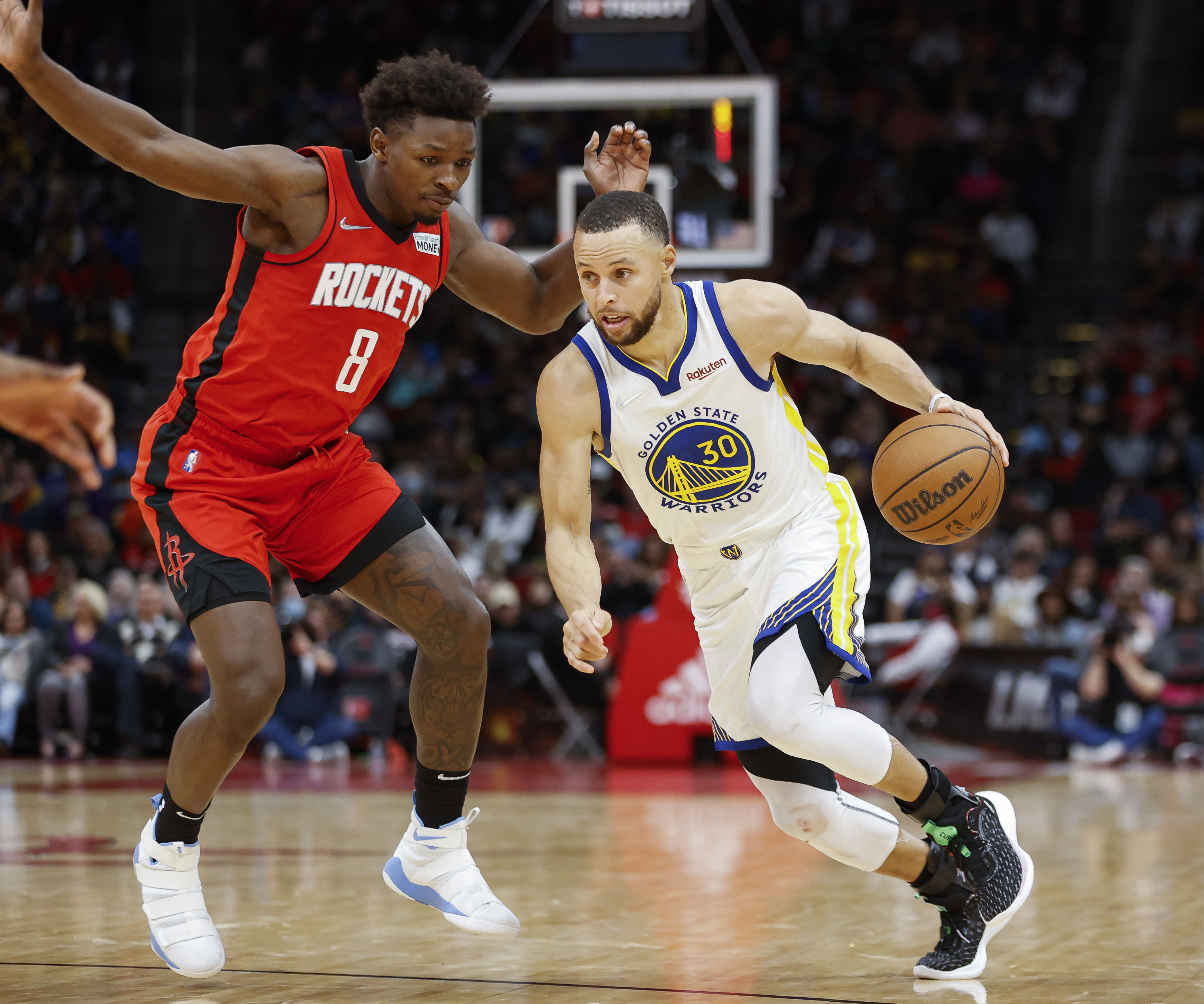 Golden State Warriors guard Stephen Curry (30) drives with the ball as Houston Rockets forward Jae’Sean Tate (8) defends during the fourth quarter at Toyota Center.