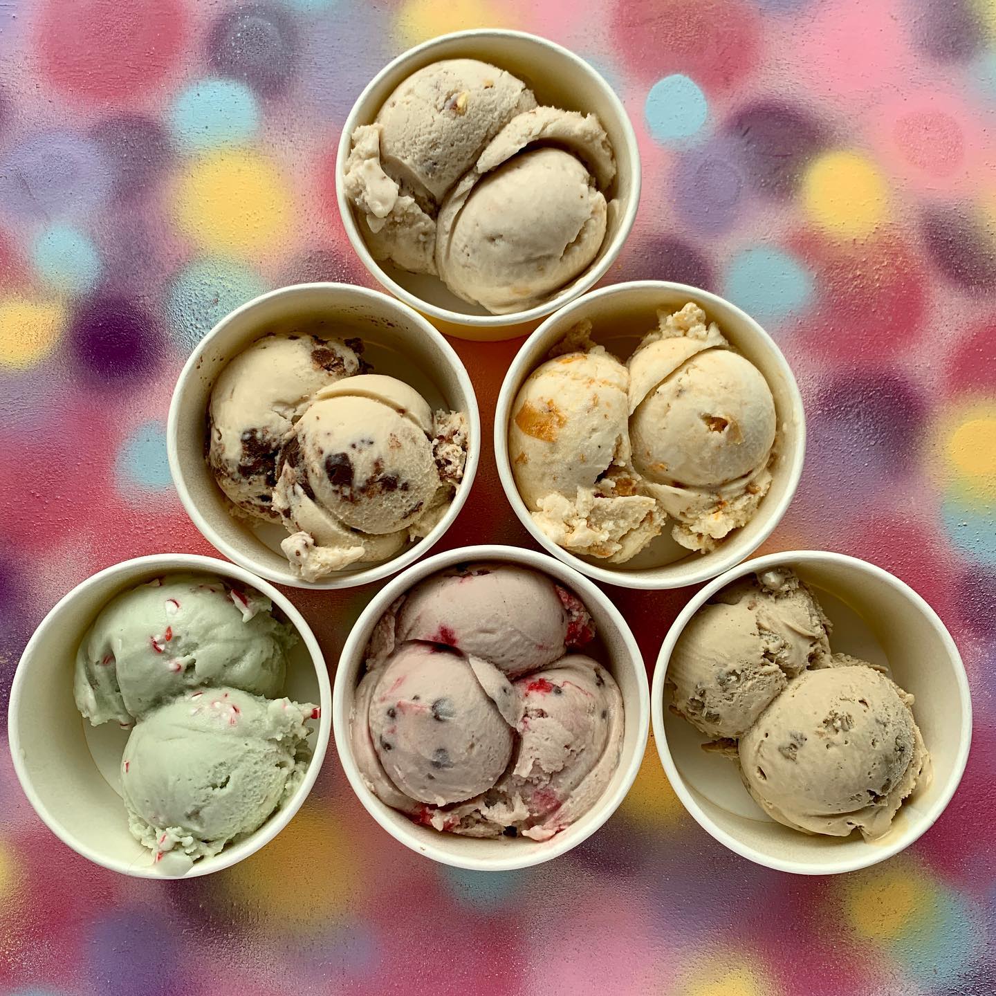 Six cups of ice cream scoops positioned in a triangle shape.
