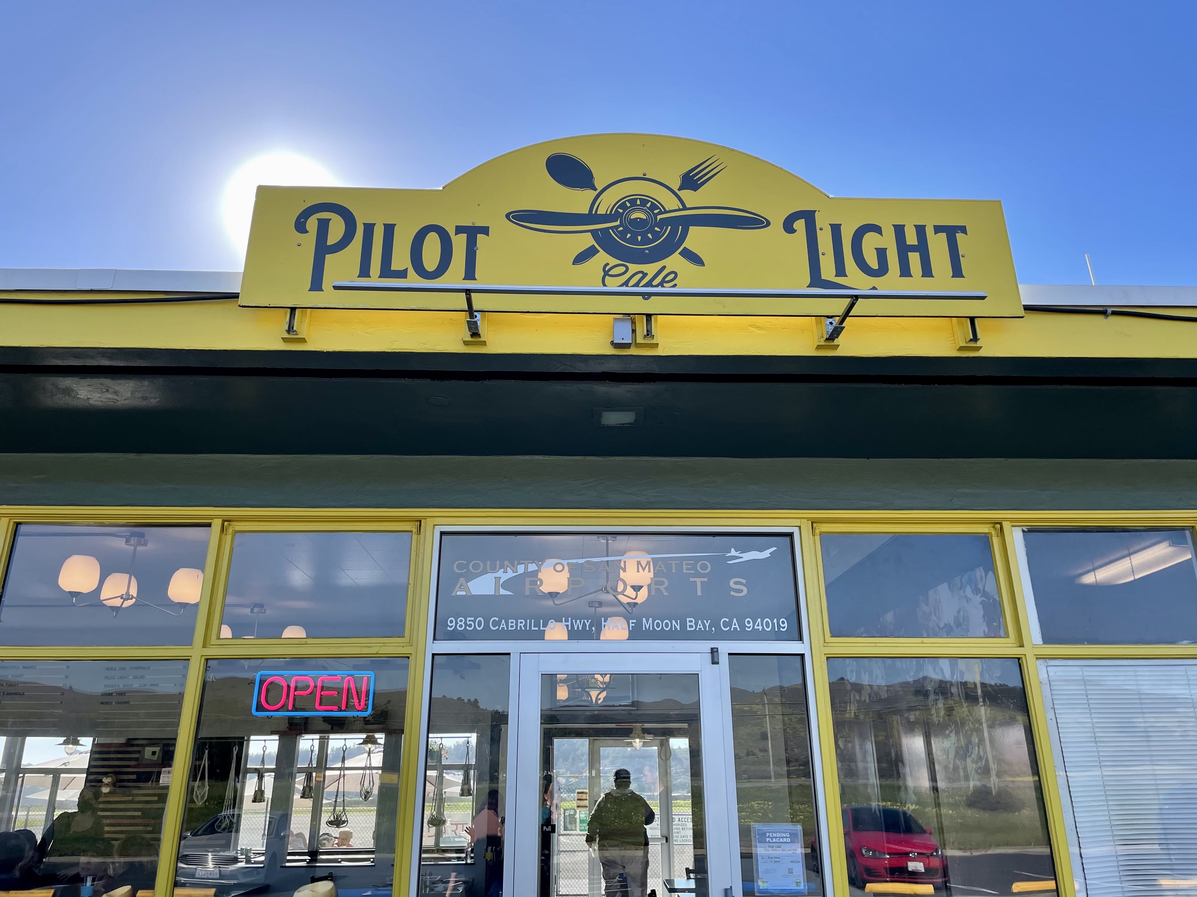 The yellow and blue sign on top of Pilot Light Cafe.