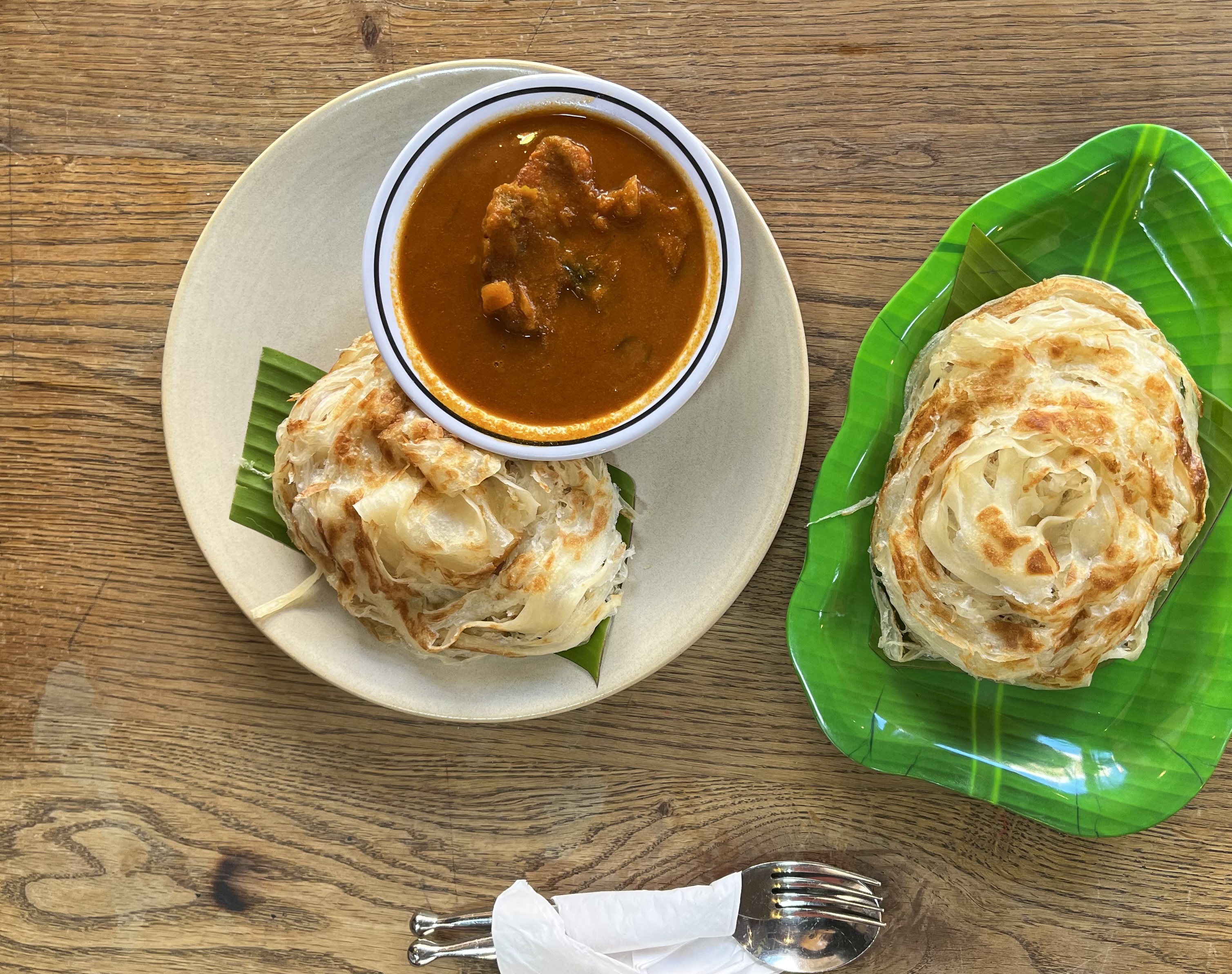 Fish curry and roti prata on a green plate at Hawker’s Kitchen in King’s Cross