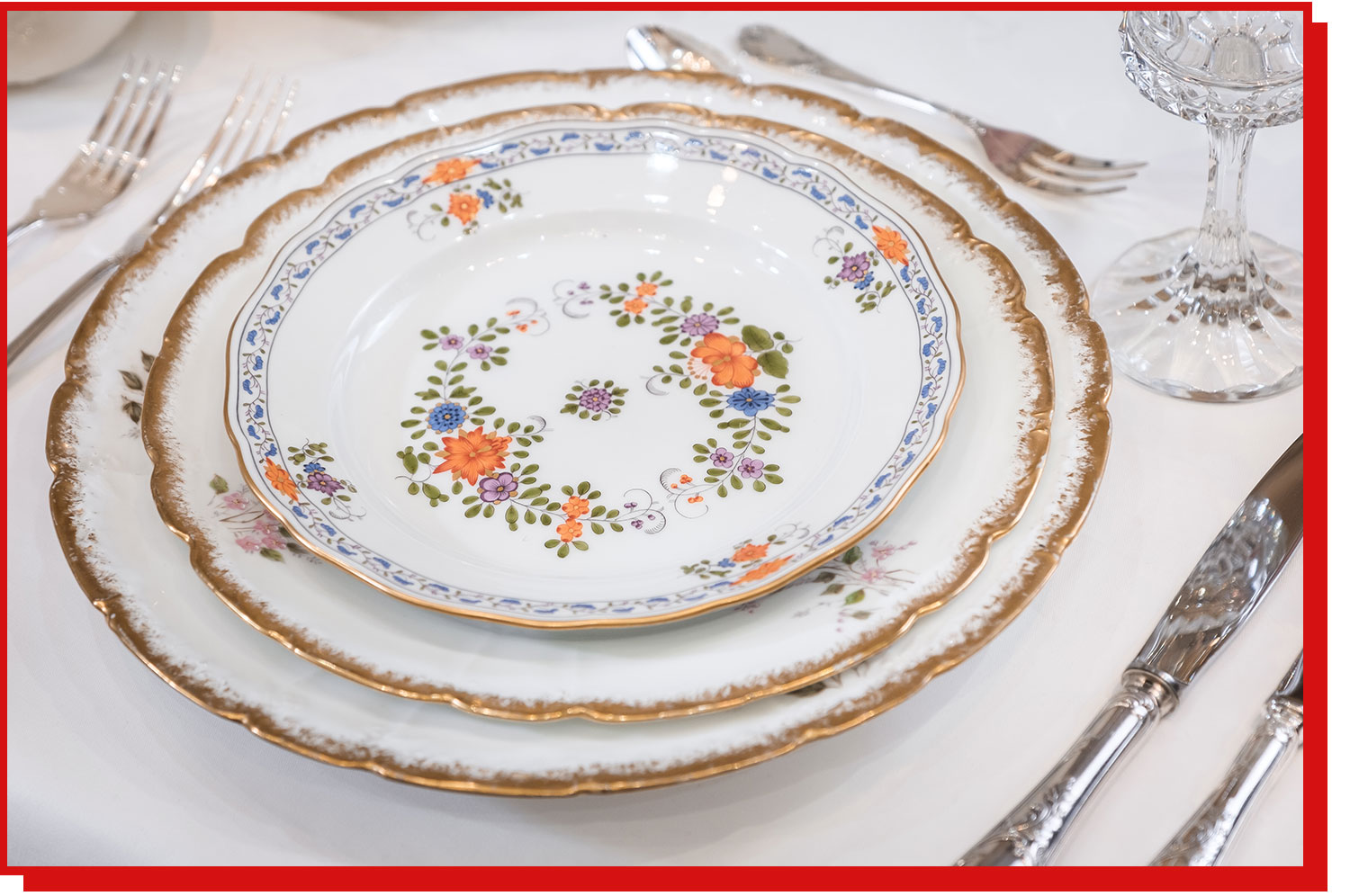 A tablesetting with vintage-style porcelain china and a crystal wine glass.