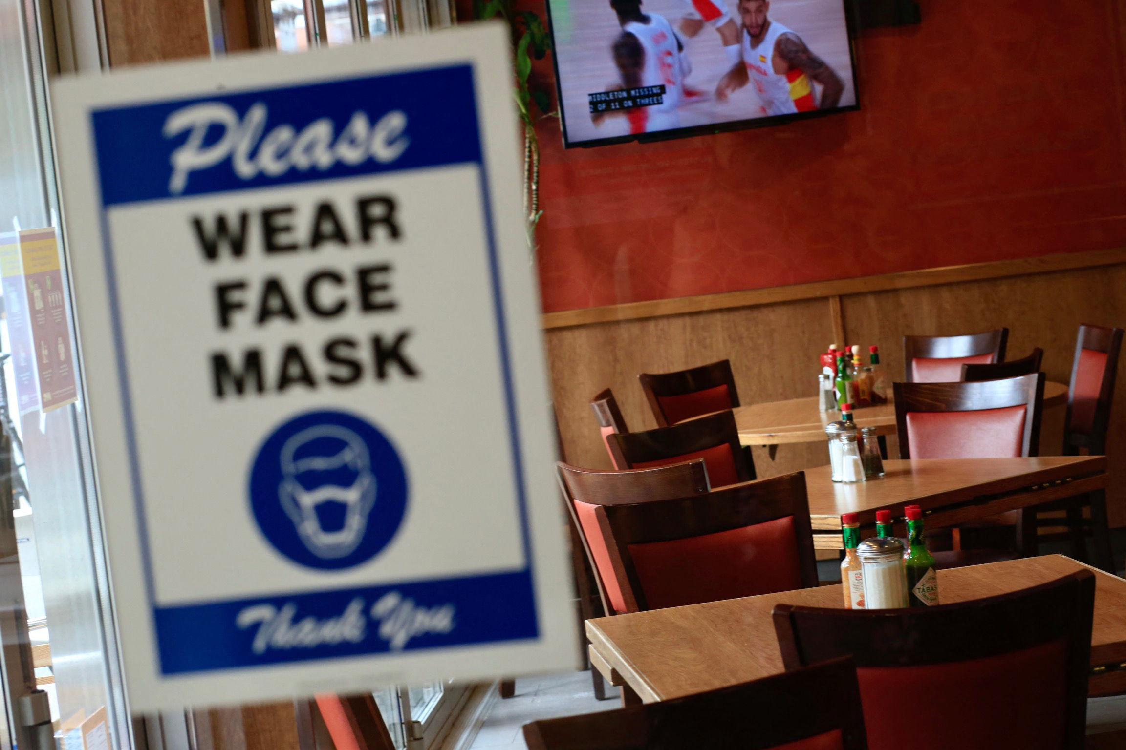 在中城的一家餐馆的入口处，一个要求顾客戴口罩的标志出现了。
