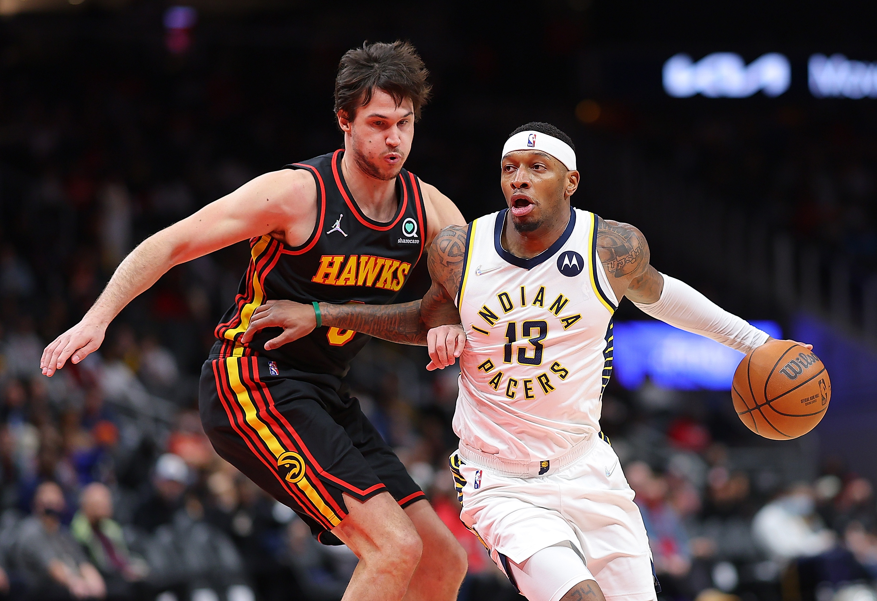Torrey Craig #13 of the Indiana Pacers drives against Danilo Gallinari #8 of the Atlanta Hawks during the first half at State Farm Arena on February 08, 2022 in Atlanta, Georgia.