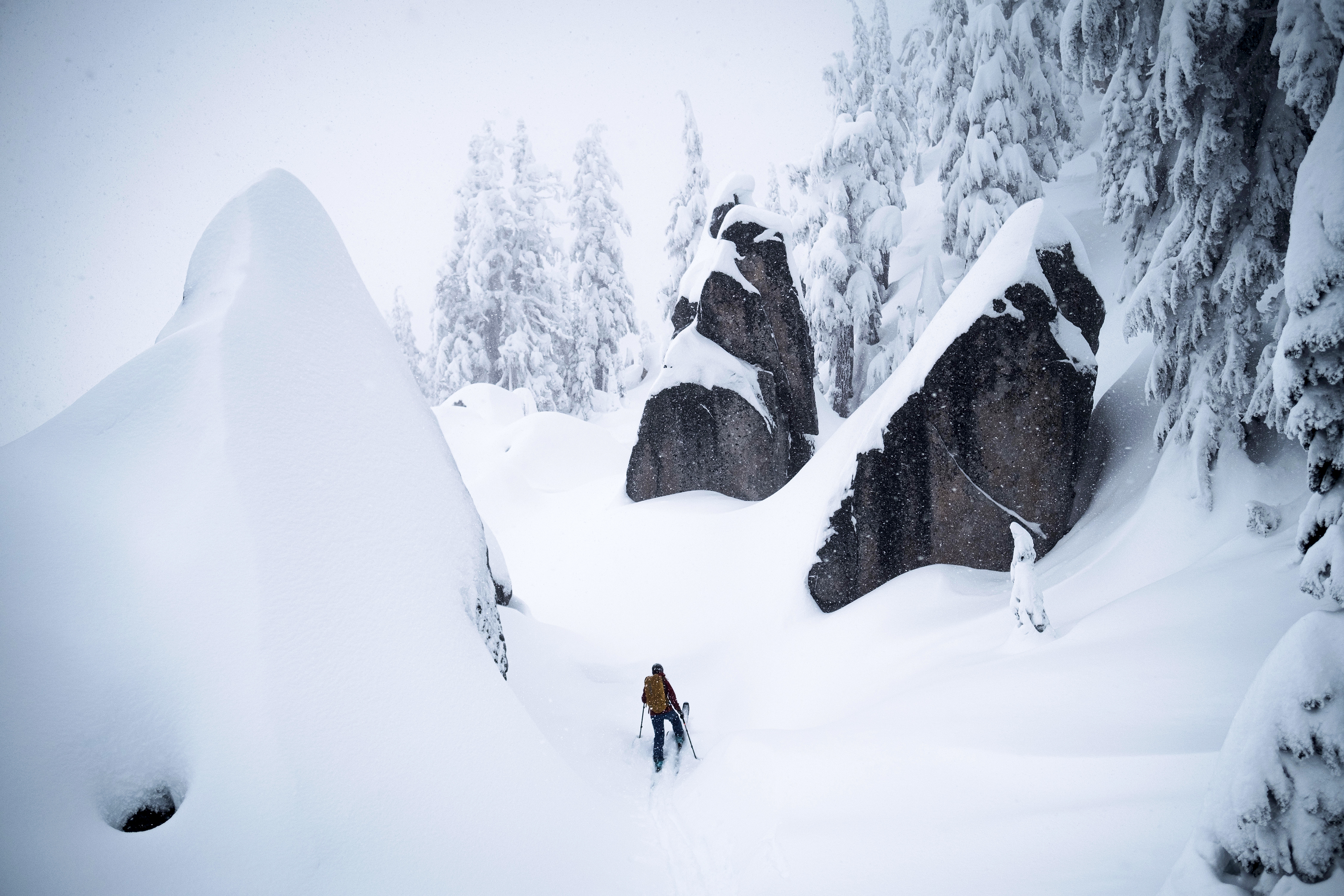 A person climbing a snow-covered mountainside.