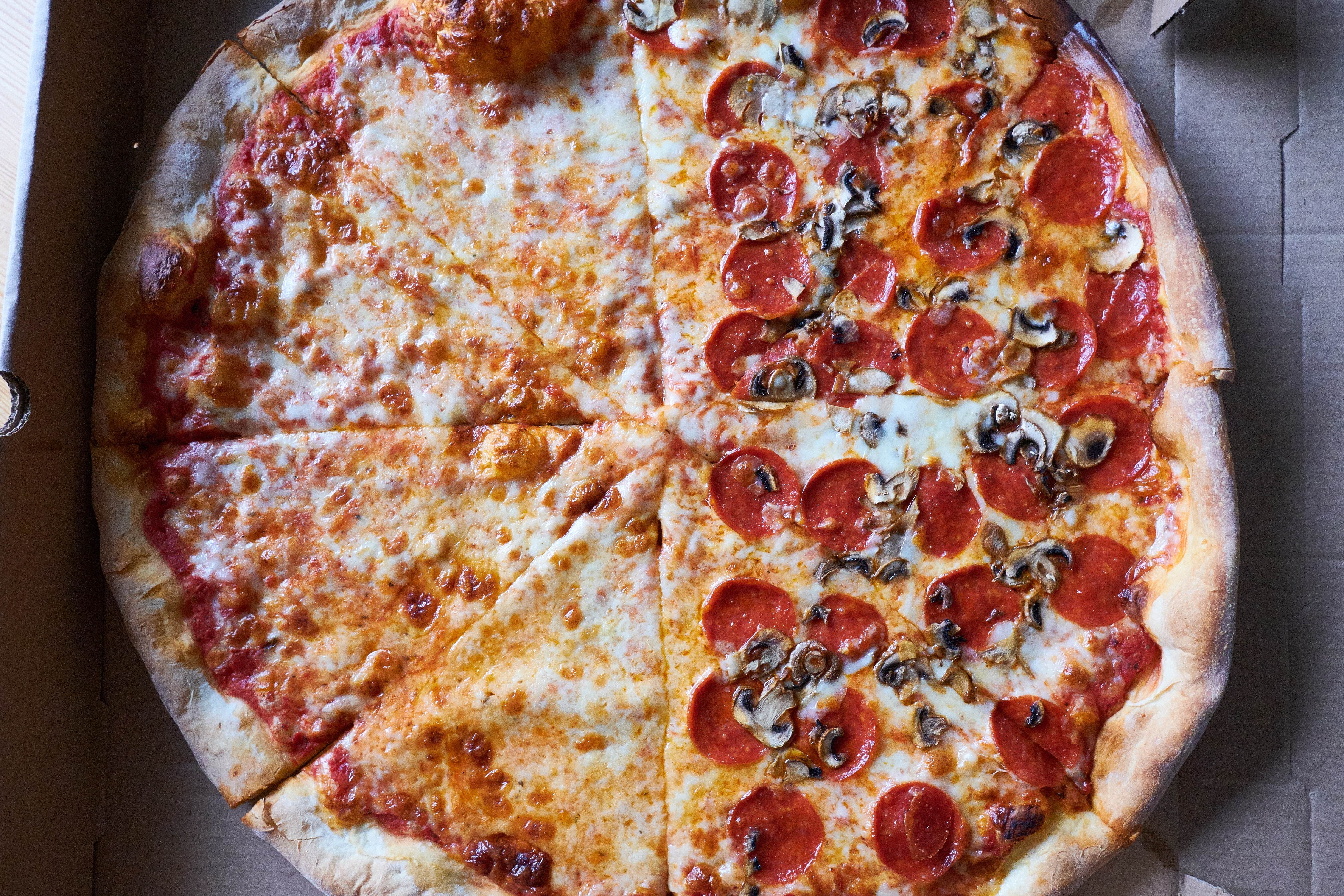 A whole pizza, half cheese, half pepperoni and mushroom.