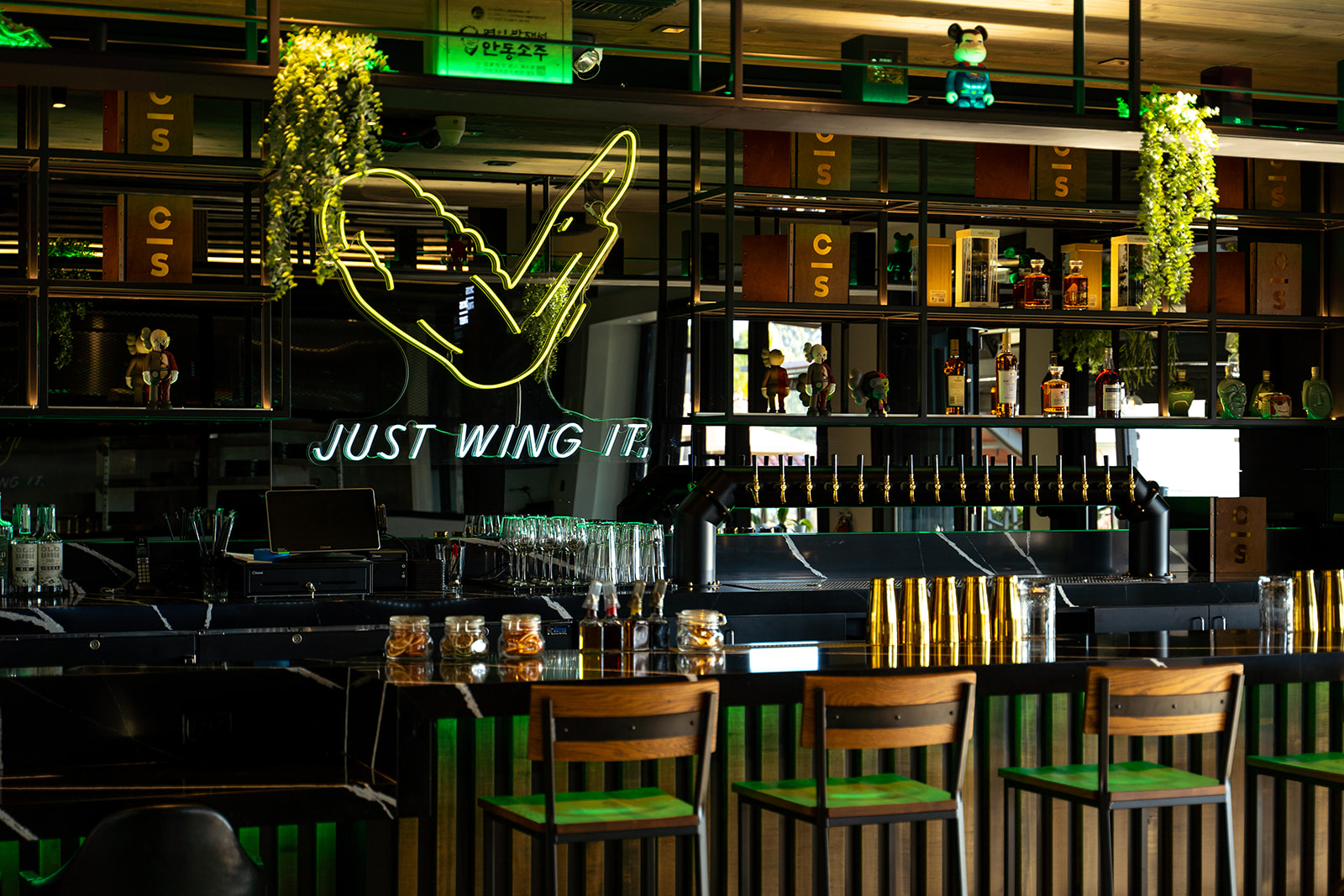 A neon sign of a chicken wing that says “Just Wing It”.