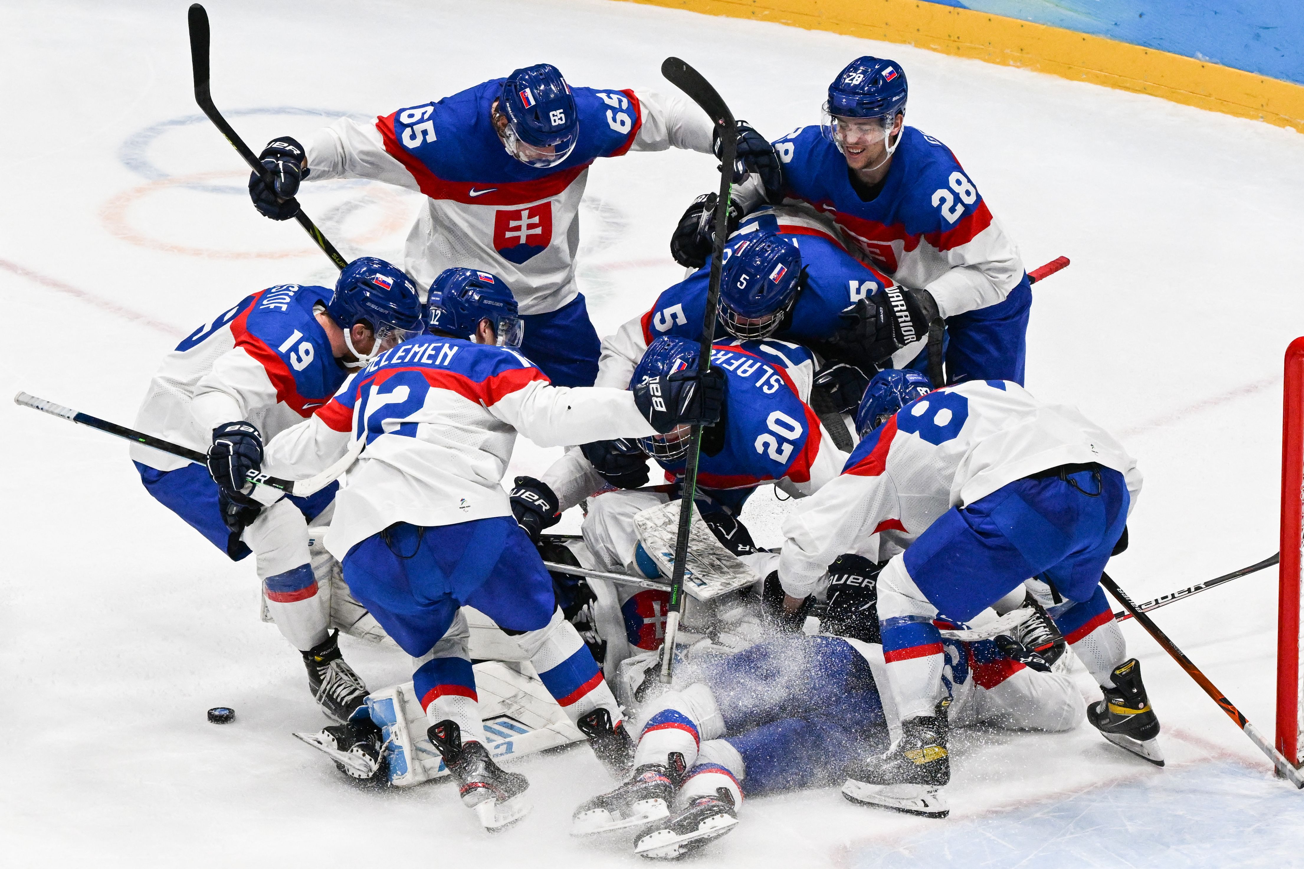 Slovakia’s players celebrate victory during the men’s play-off quarterfinal match of the Beijing 2022 Winter Olympic Games ice hockey competition between USA and Slovakia, at the National Indoor Stadium in Beijing on February 16, 2022.