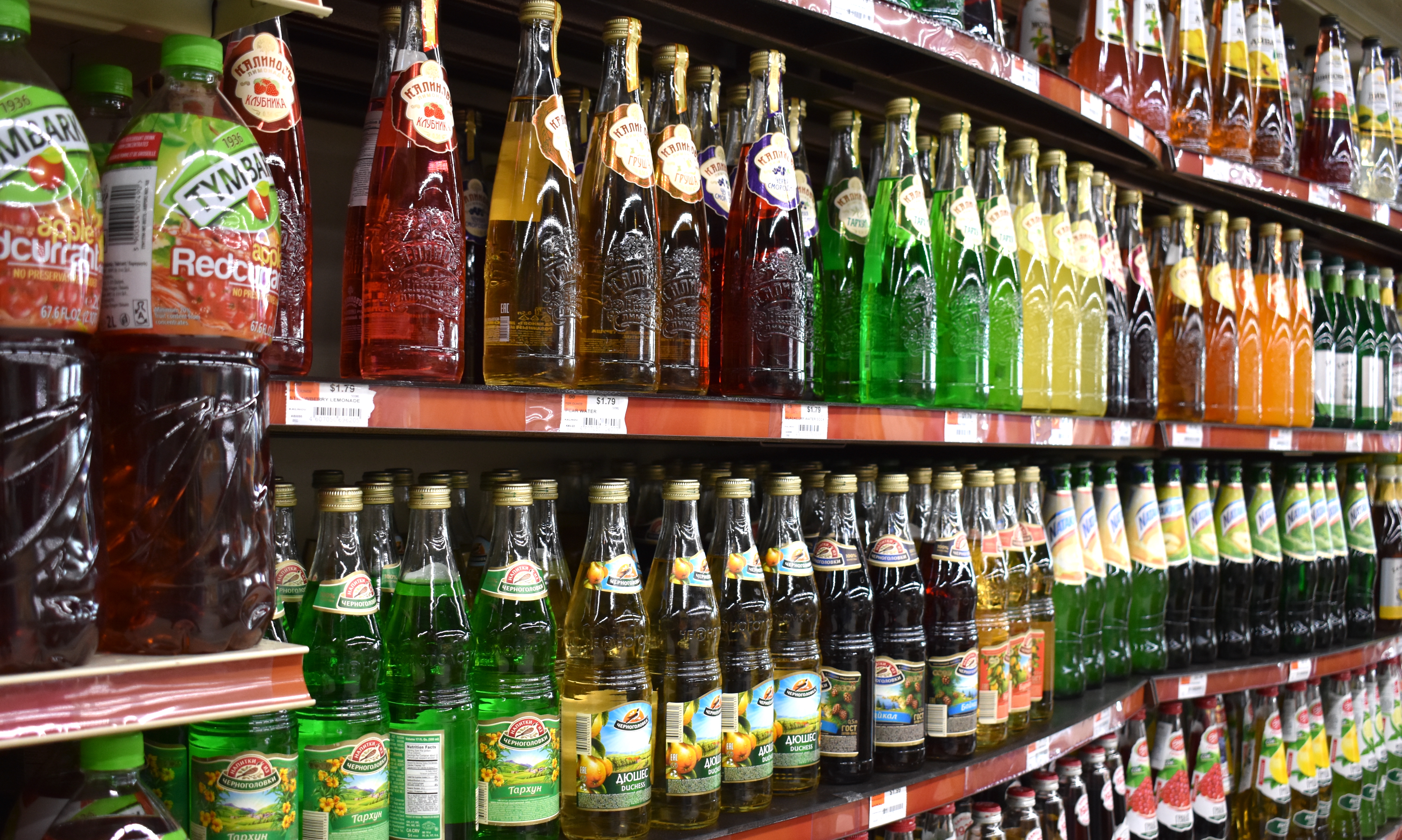 A line of colorful soda bottles on a shelf. 