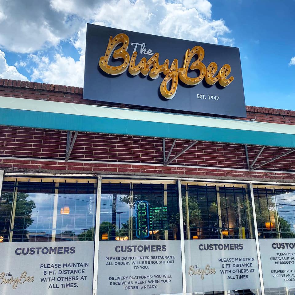 The outside neon yellow signage for Busy Bee Cafe in Atlanta, GA.
