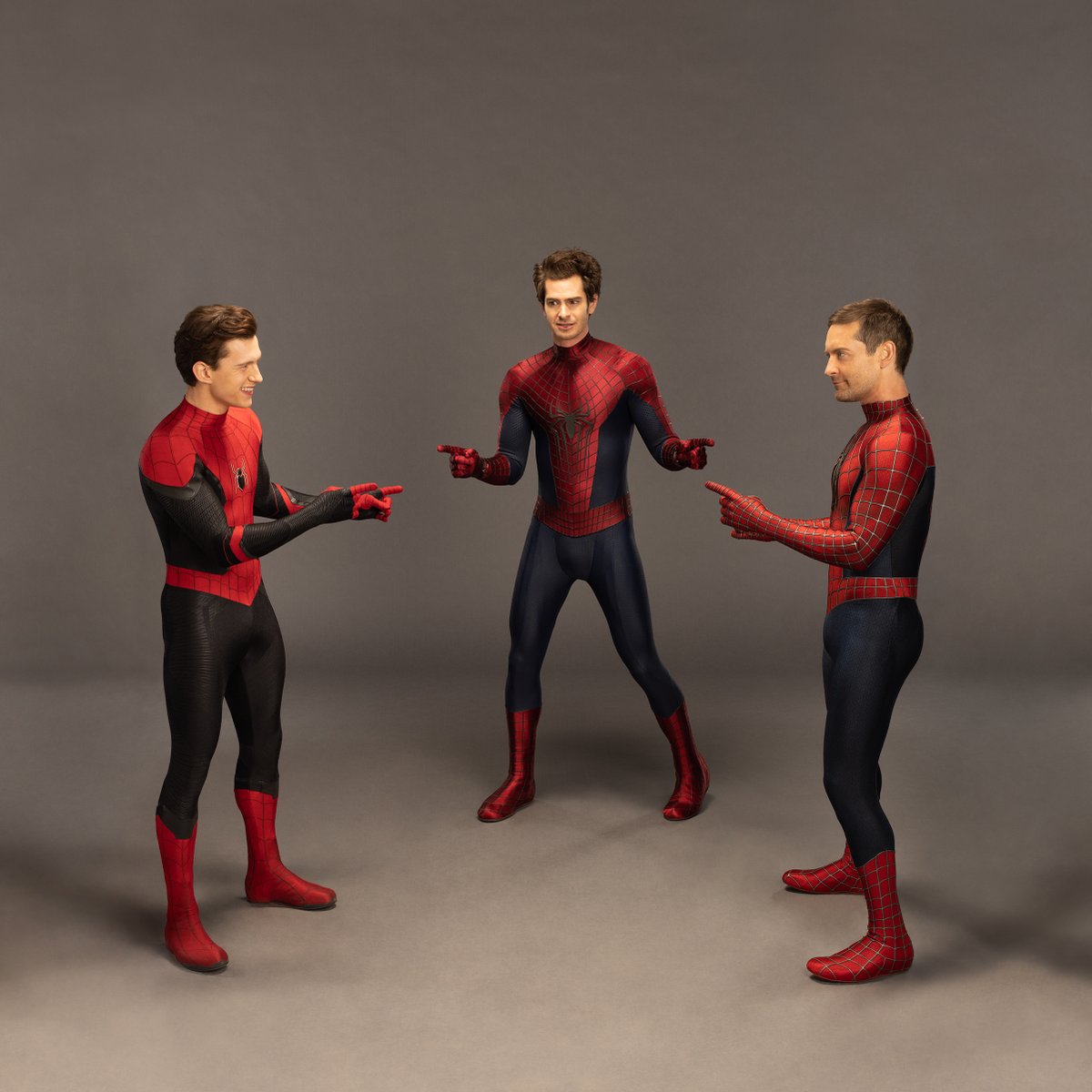 LtR, Tom Holland, Andrew Garfield, and Tobey Maguire point at each other, wearing their Spider-Man costumes but no masks, in imitation of the meme.