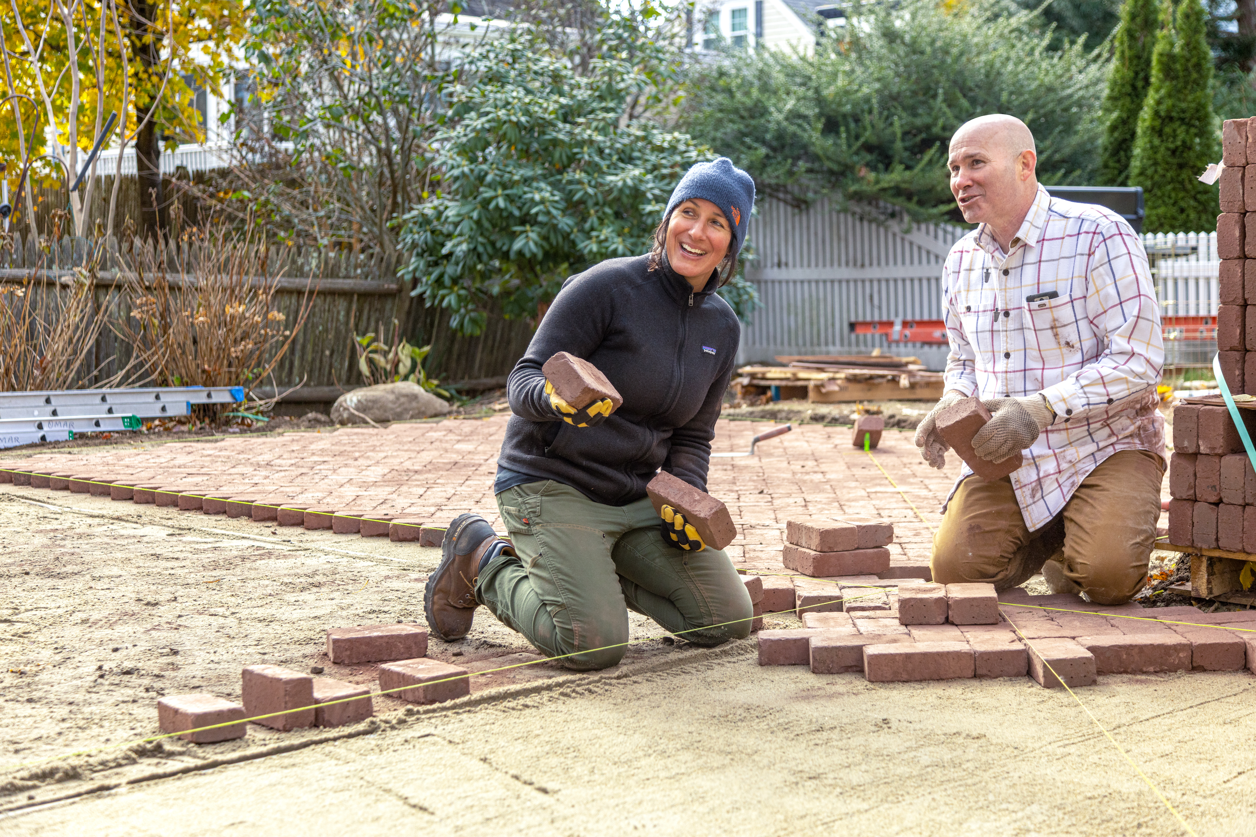 S43 E20, Jenn Nawada and Mark McCullough work on a brick patio