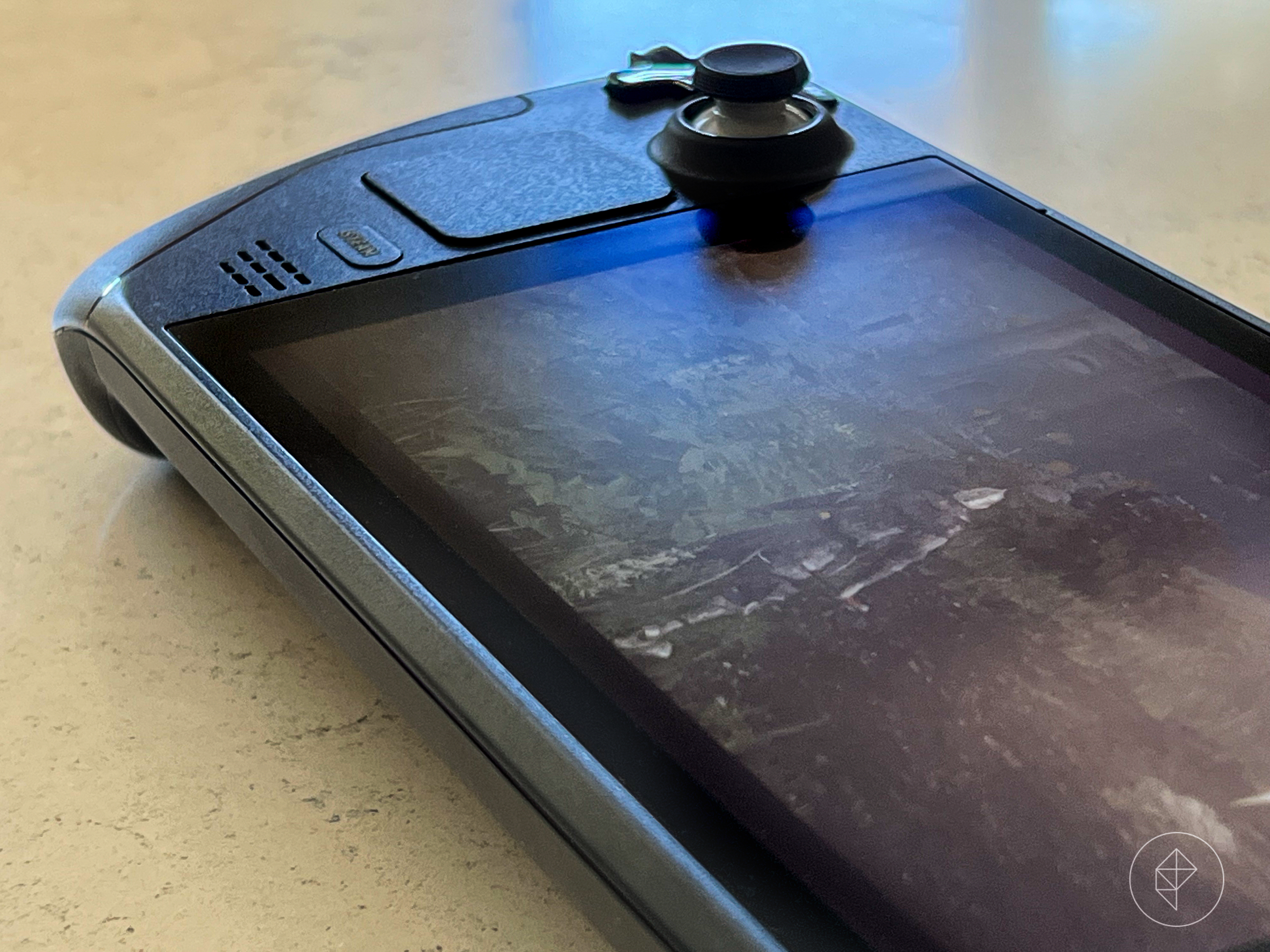 Close up photo of Steam Deck hand-held gaming device on stone surface