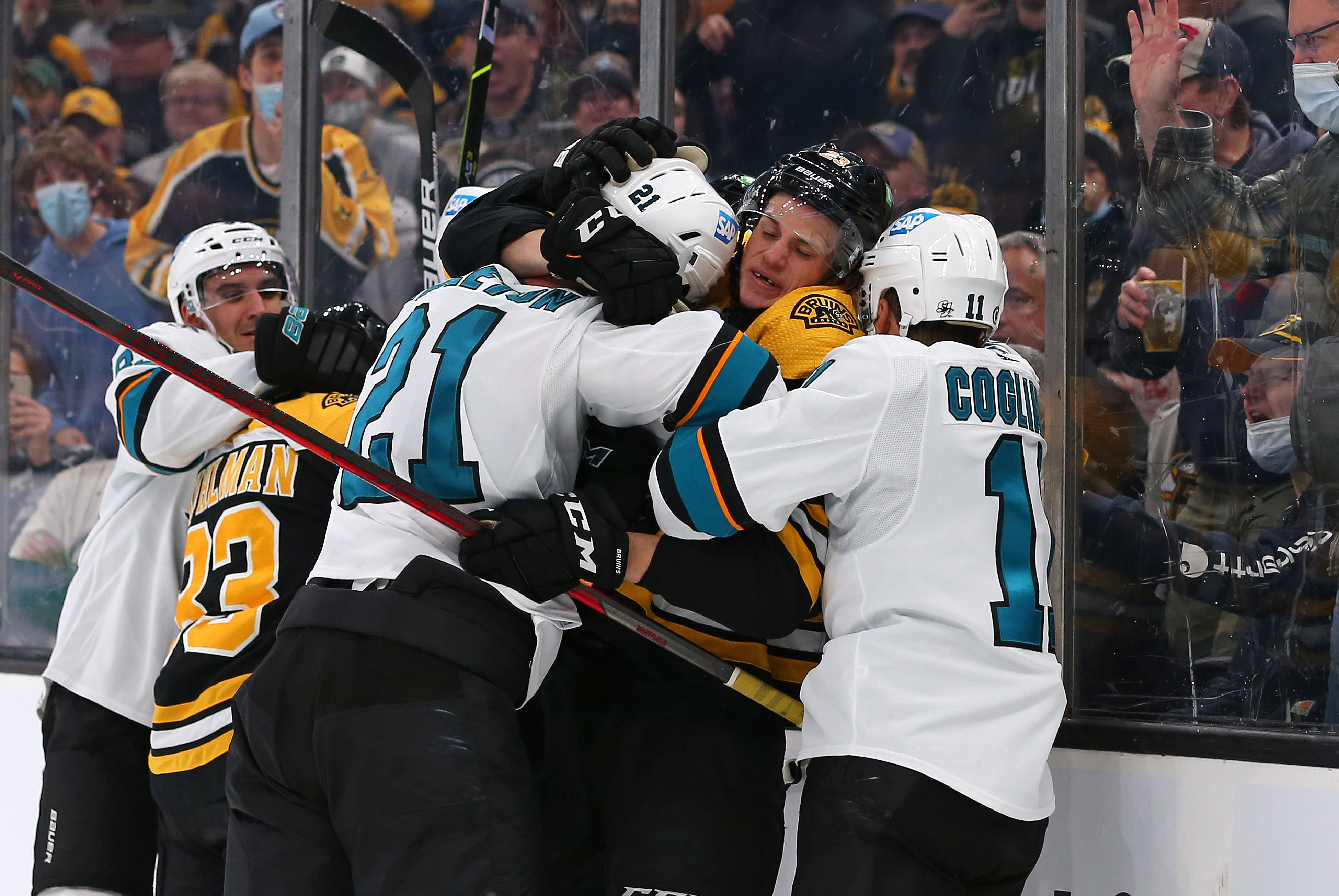 San Jose Sharks defenseman Jacob Middleton (21) and Boston Bruins left wing Trent Frederic (11) shove one another during a NHL game between San Jose Sharks and Boston Bruins on October 24, 2021, at TD Garden in Boston, MA.