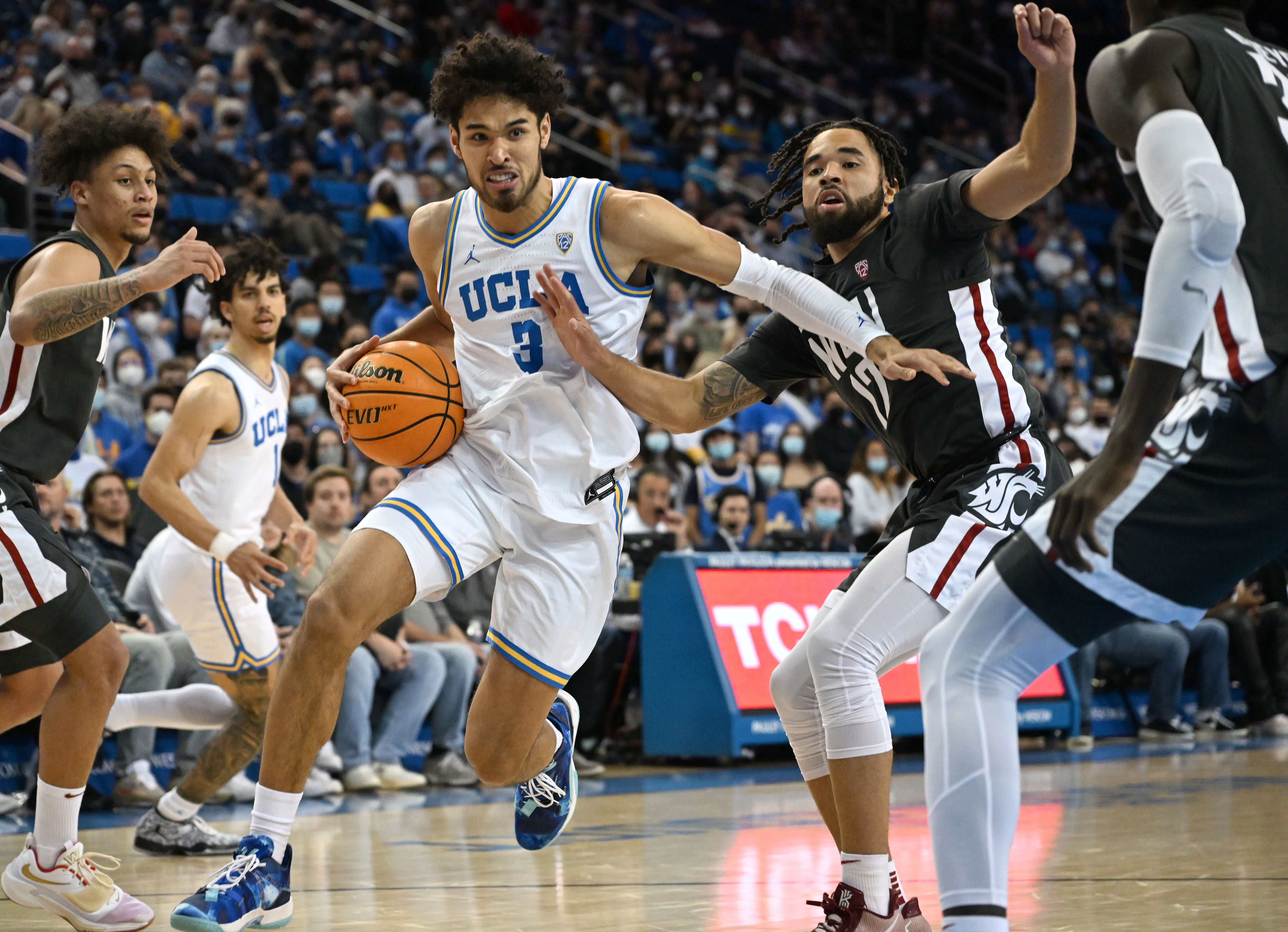 UCLA Bruins guard Johnny Juzang drives to the basket past Washington State Cougars guard Michael Flowers in the second half of the game at Pauley Pavilion presented by Wescom.&nbsp;