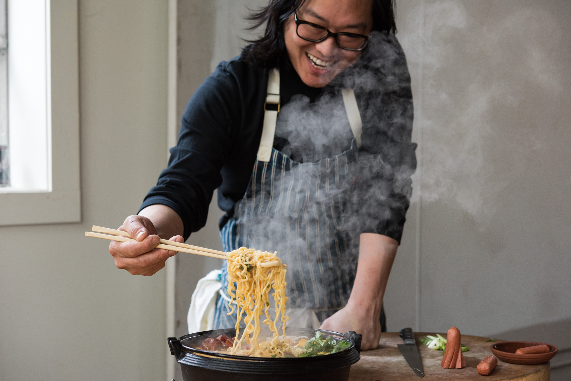 Peter Cho of Han Oak pulls noodles from a skillet.