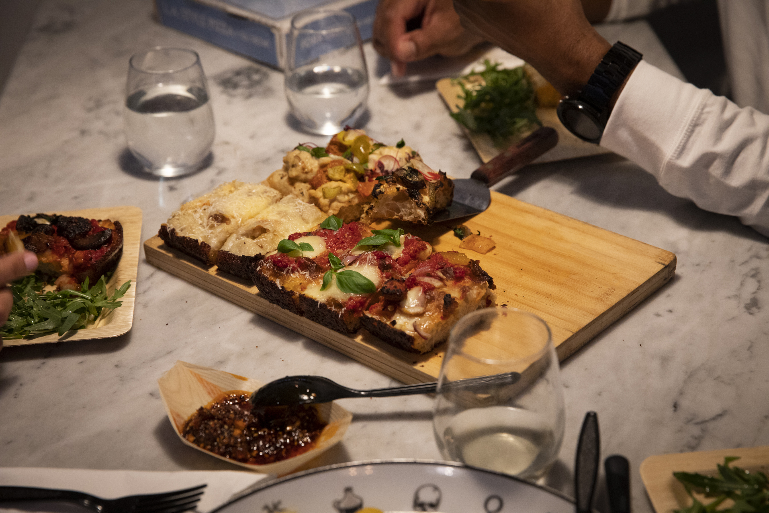 An evening over a pizza on a cutting board with sides around.