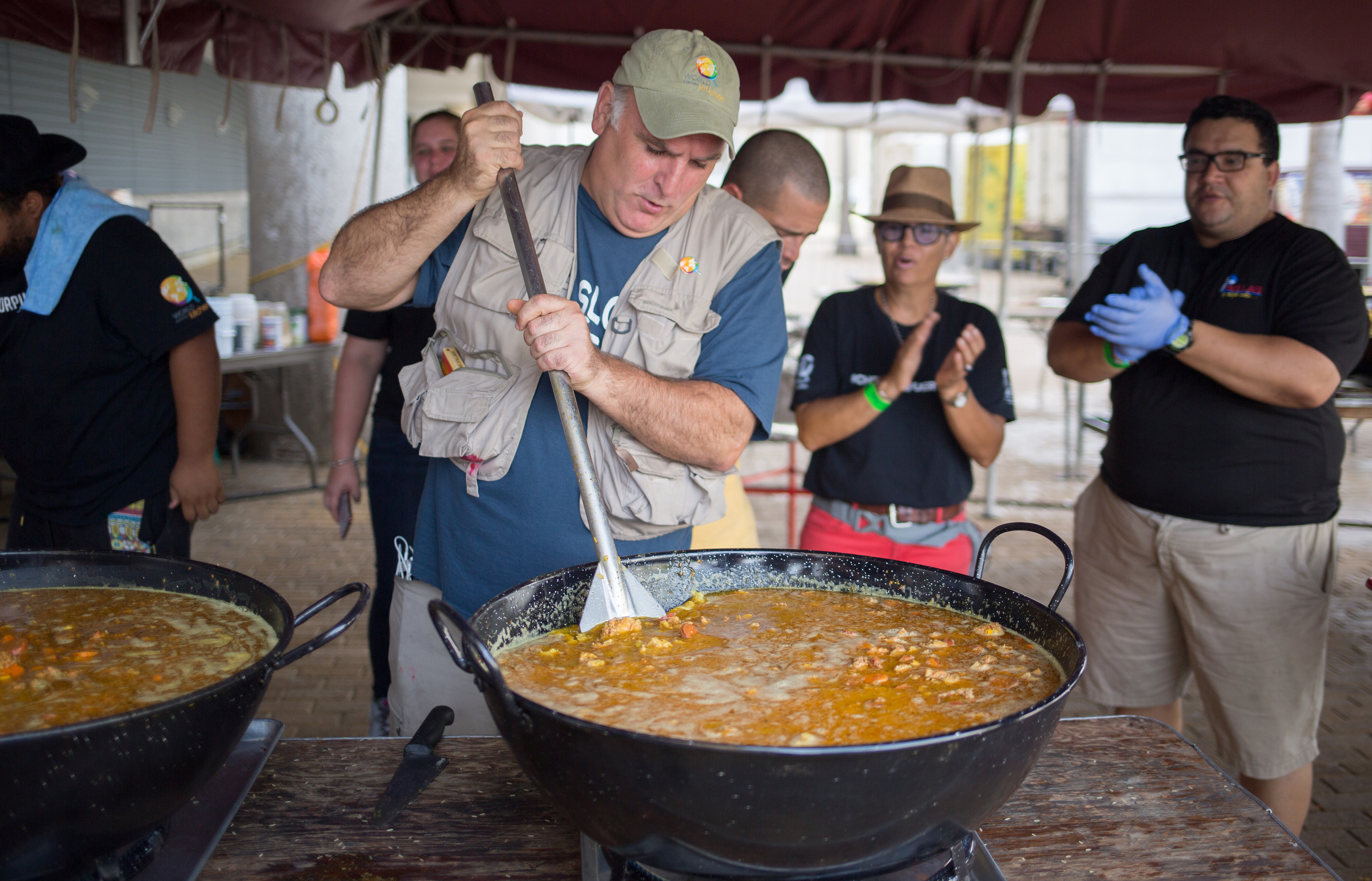 A man stirring a very large pot of soup.