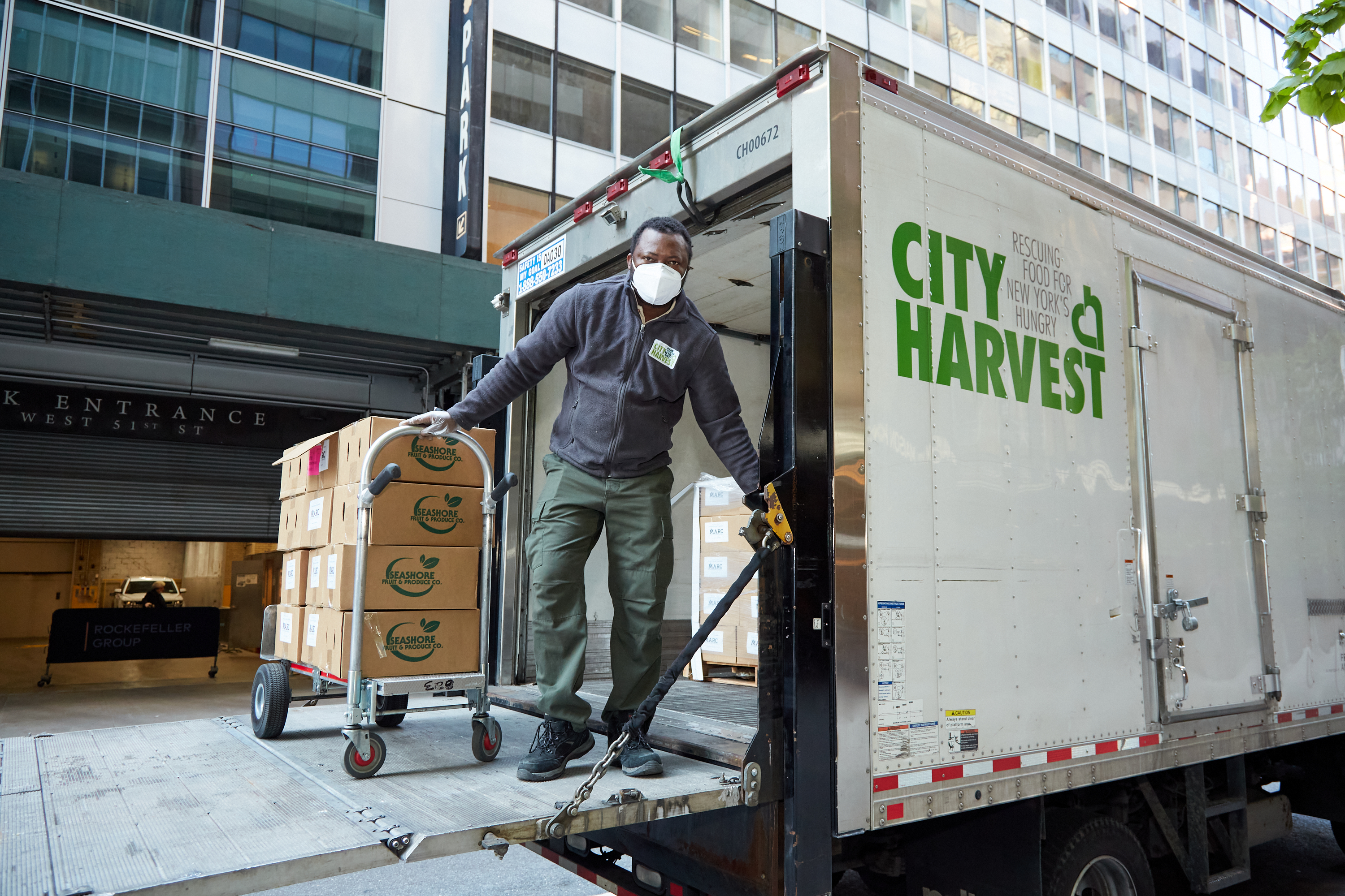 A man unloads boxes from a City Harvest truck