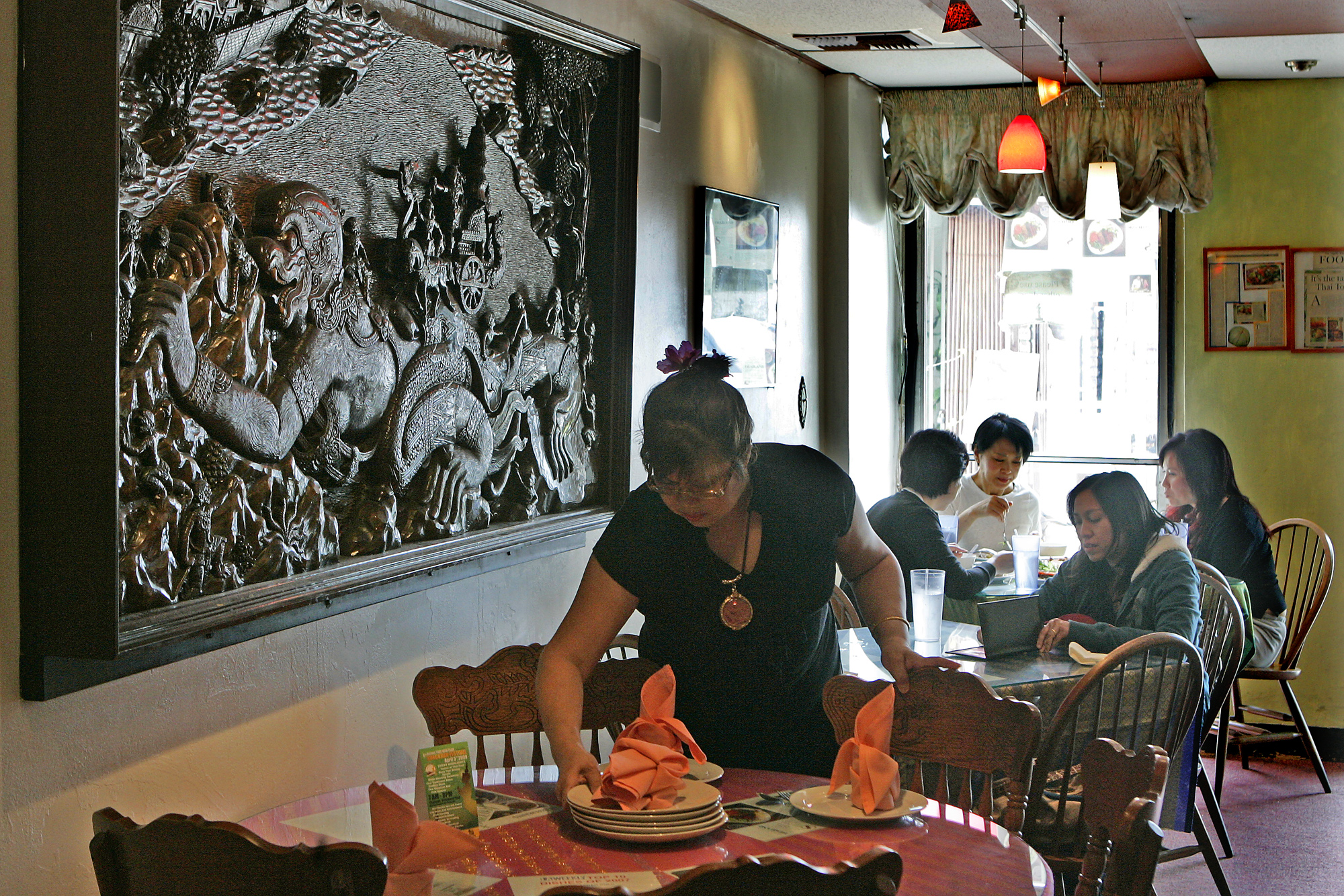 Jazz Singsanong, owner of Jitlada prepares table setting at her Thai restaurant in Hollywood. April