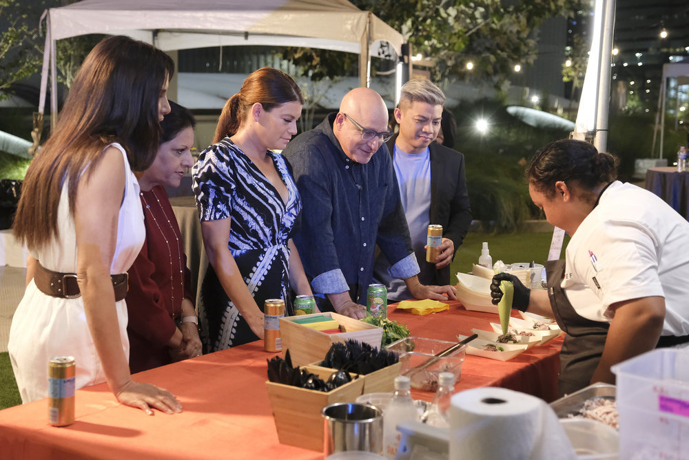 “Top Chef: Houston” judges look on at chef Evelyn Garcia’s station as she plates a Vietnamese chicken salad.