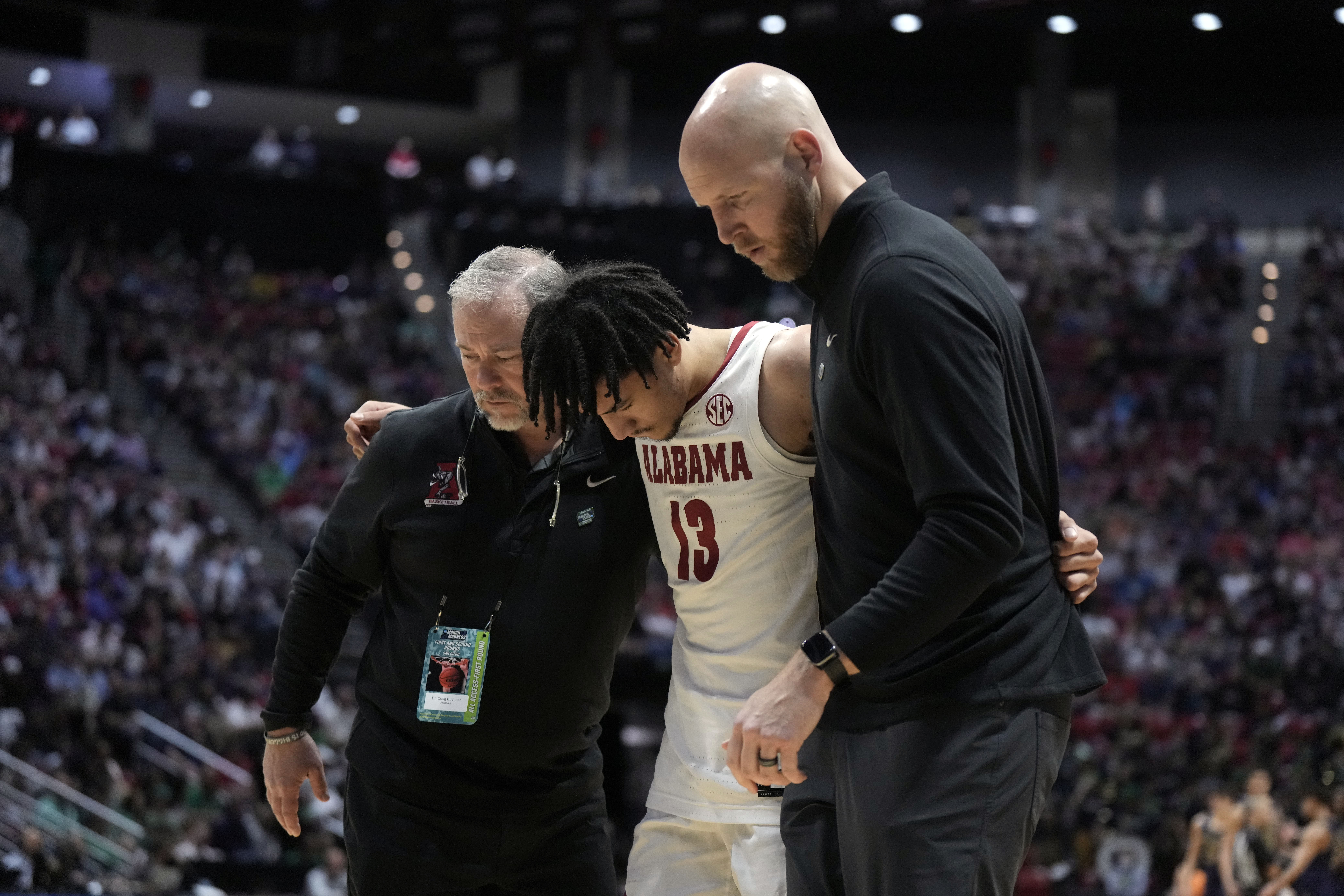 Trainers help Alabama Crimson Tide guard Jahvon Quinerly off the court after an apparent injury in the first half against the Notre Dame Fighting Irish during the first round of the 2022 NCAA Tournament at Viejas Arena.