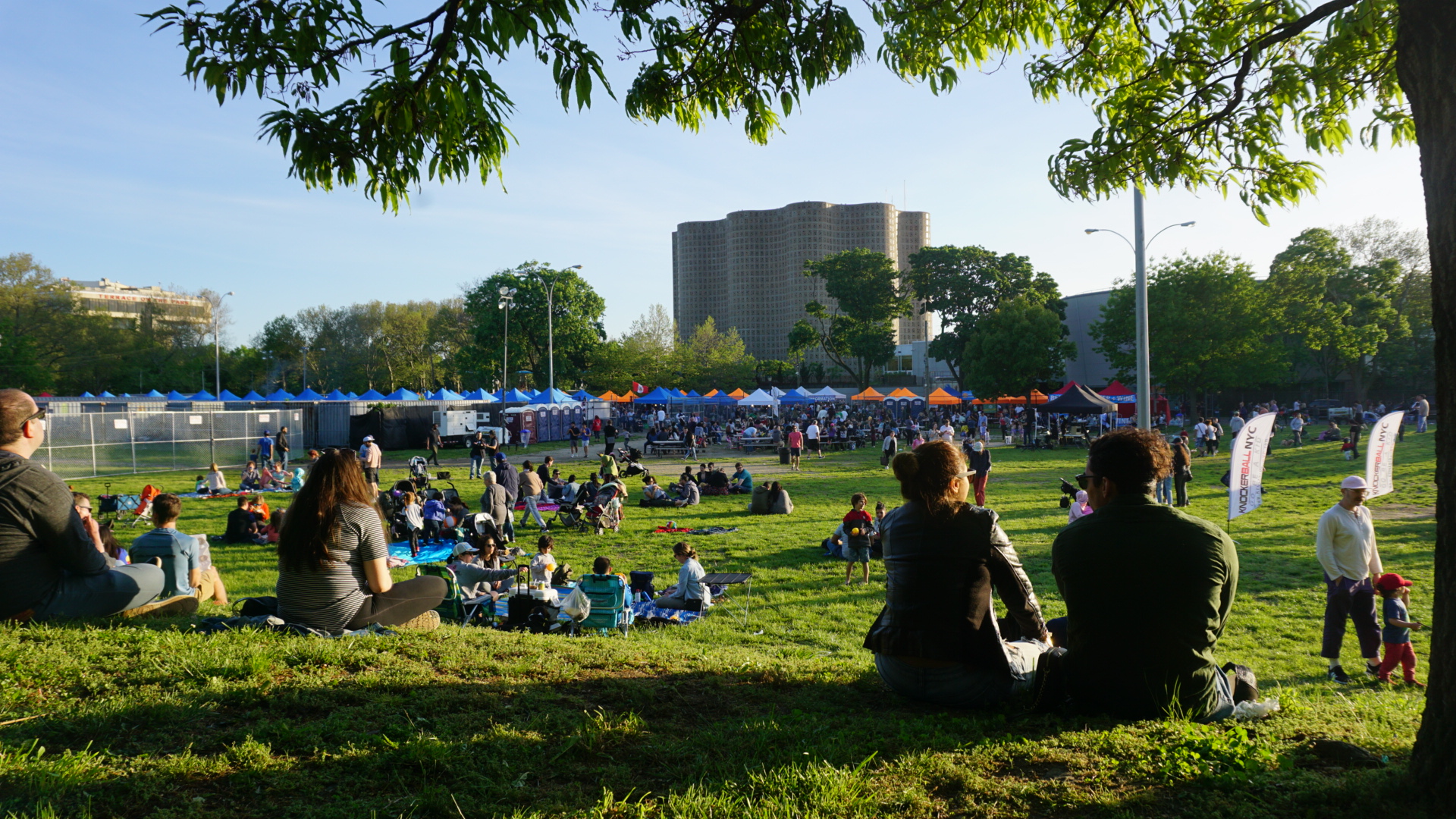 People sitting in Flushing Meadows Corona Park during the Queens Night Market’s 2019 season.