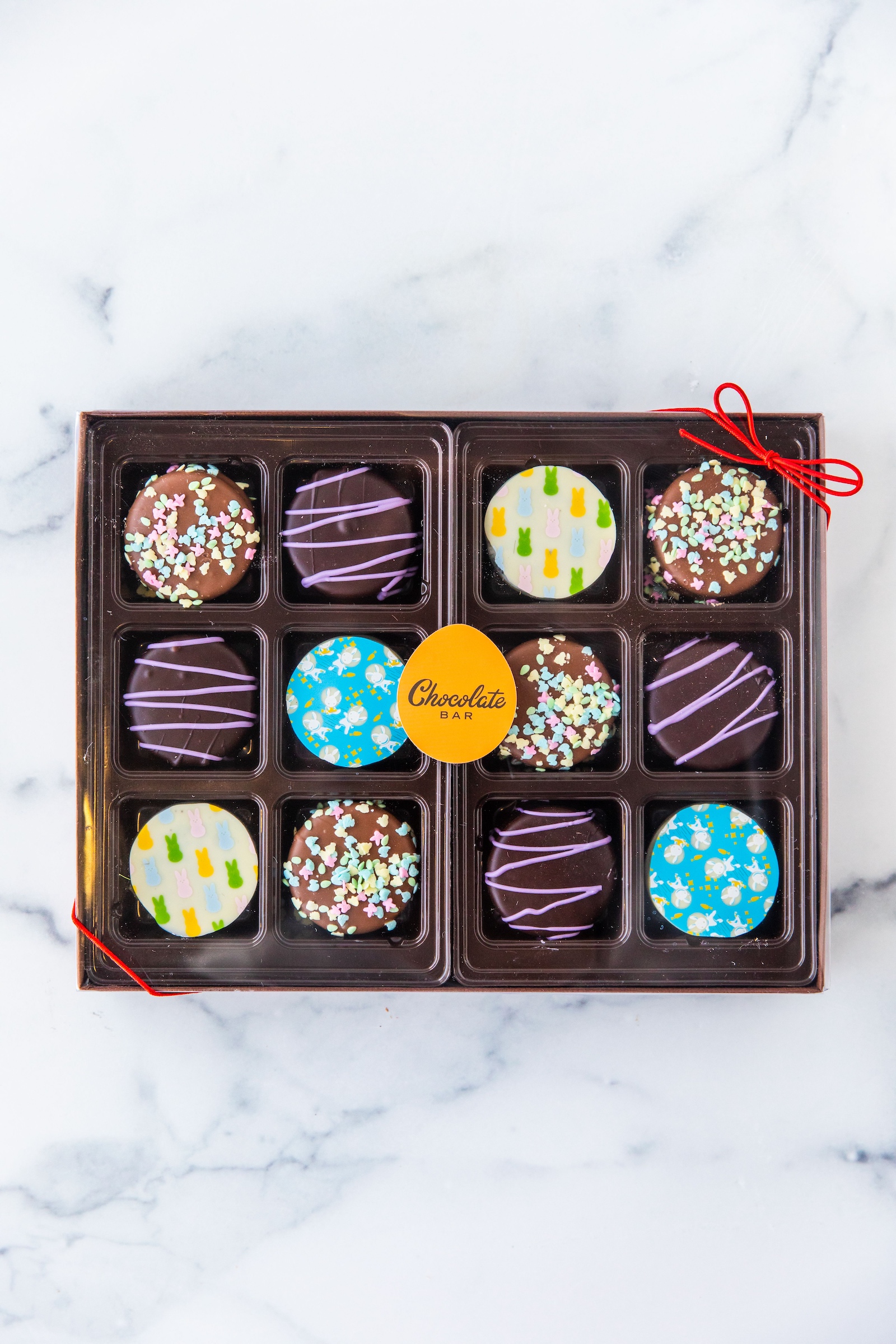 a box of brightly colored, Easter-themed chocolates from The Chocolate Bar.