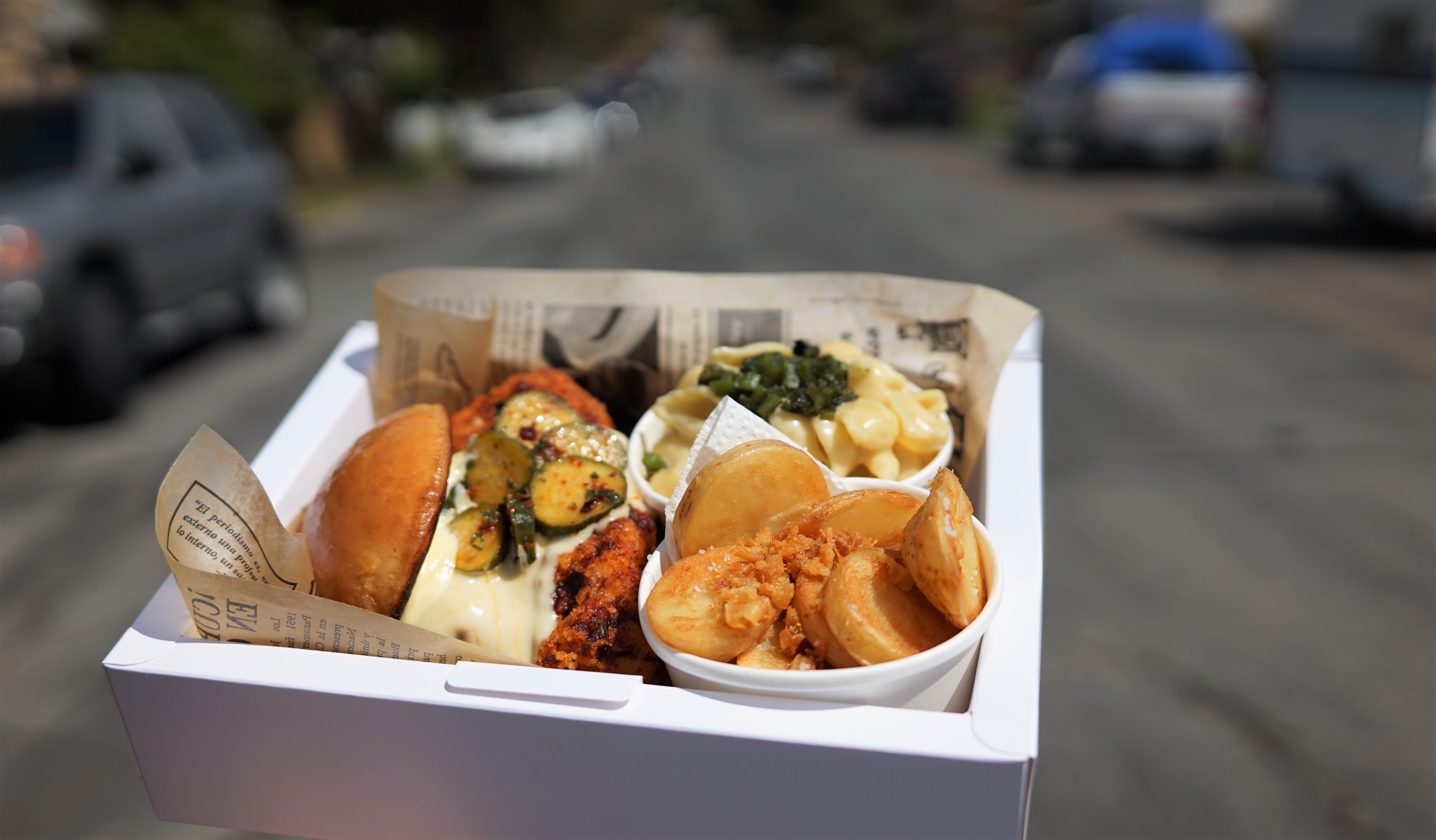 A box holding a fried chicken sandwich and sides.