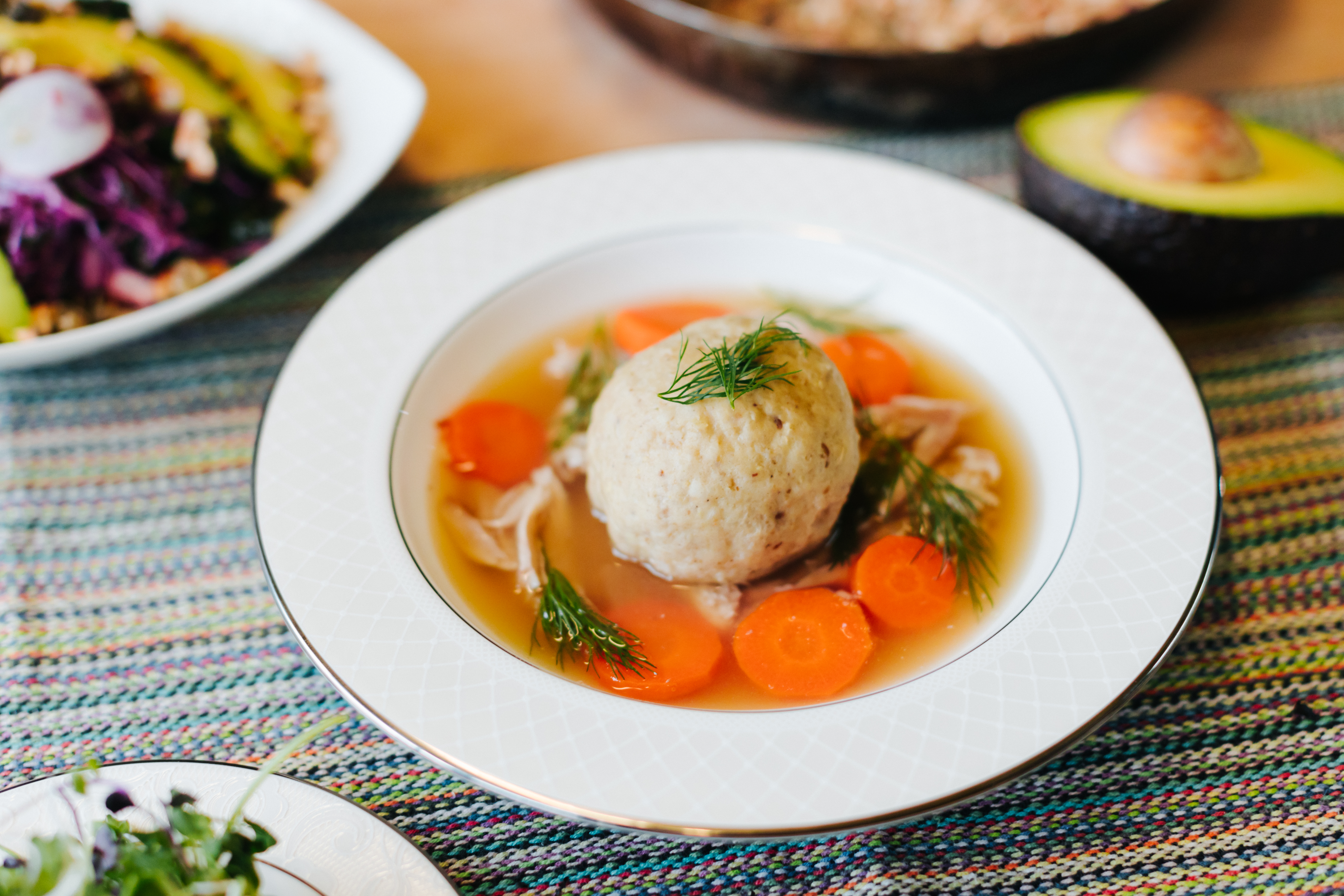 A bowl of matzo ball soup on a table at Jacob &amp; Sons in Portland, Oregon.