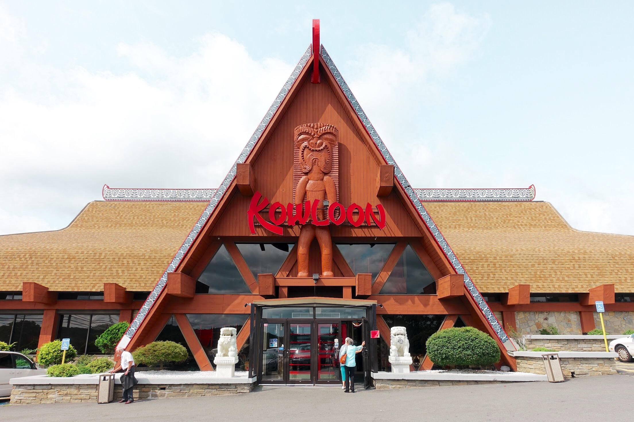 Exterior view of a restaurant with a large A-frame entrance and red signage