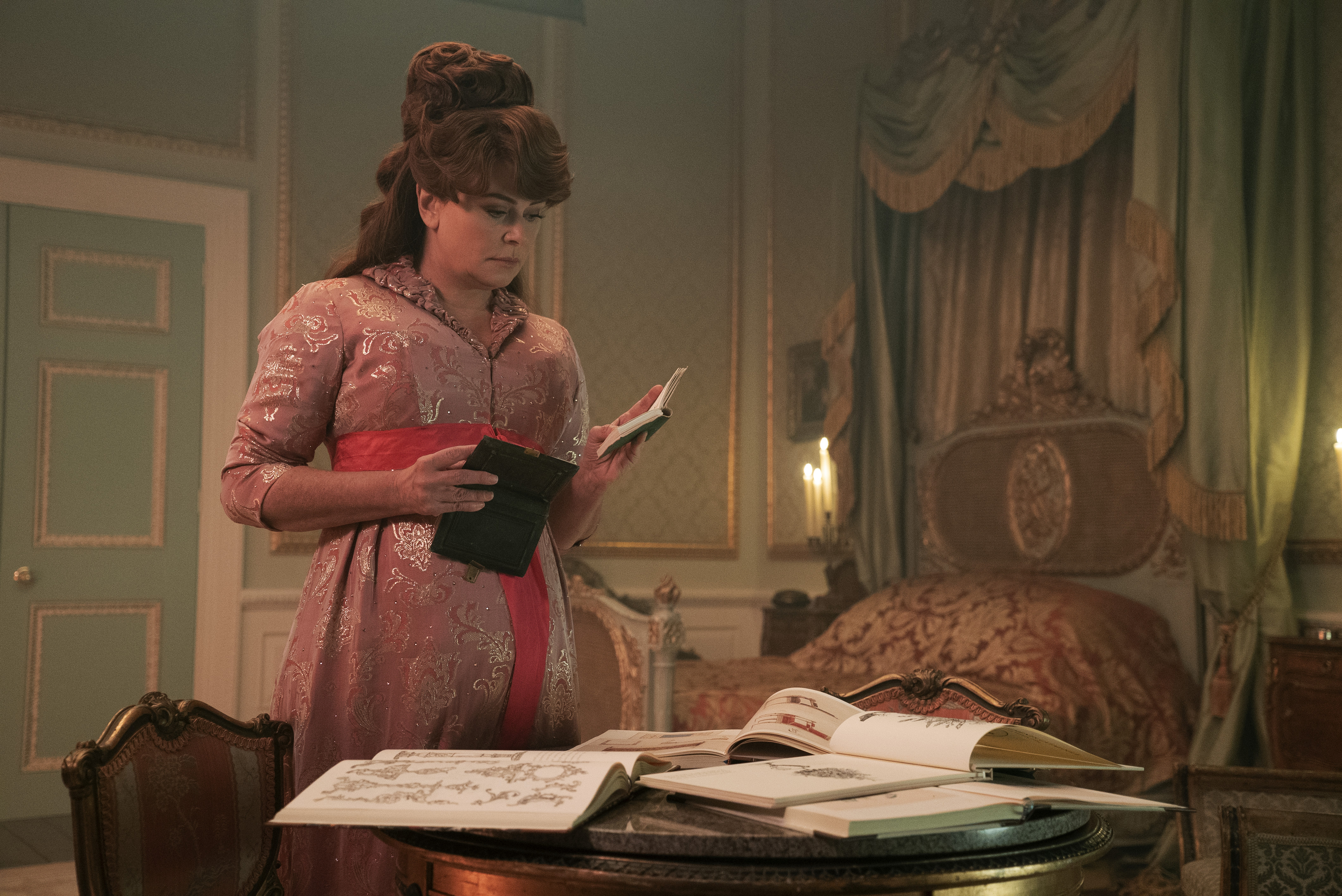 Lady Featherington inspecting the books in a still from season 2 of Bridgerton