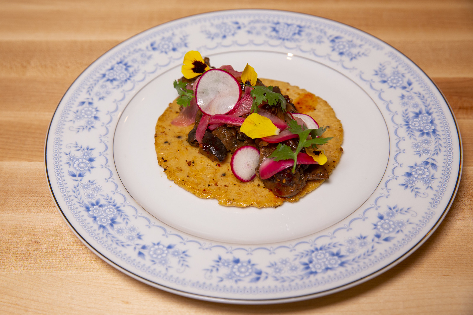 A round plate with an open-faced taco