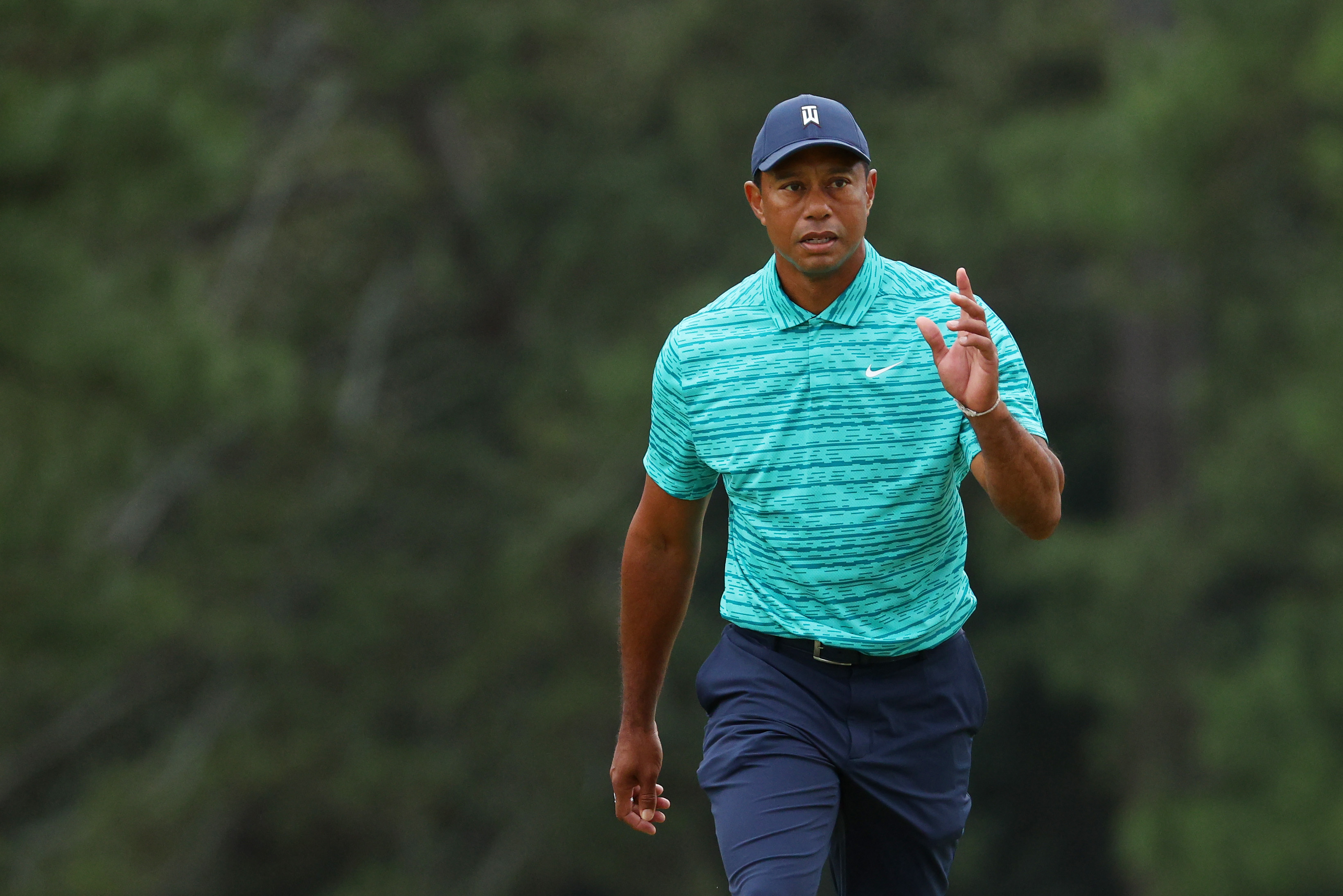 Tiger Woods waves to the crowd as he walks to the 18th green during the second round of The Masters at Augusta National Golf Club on April 08, 2022 in Augusta, Georgia.