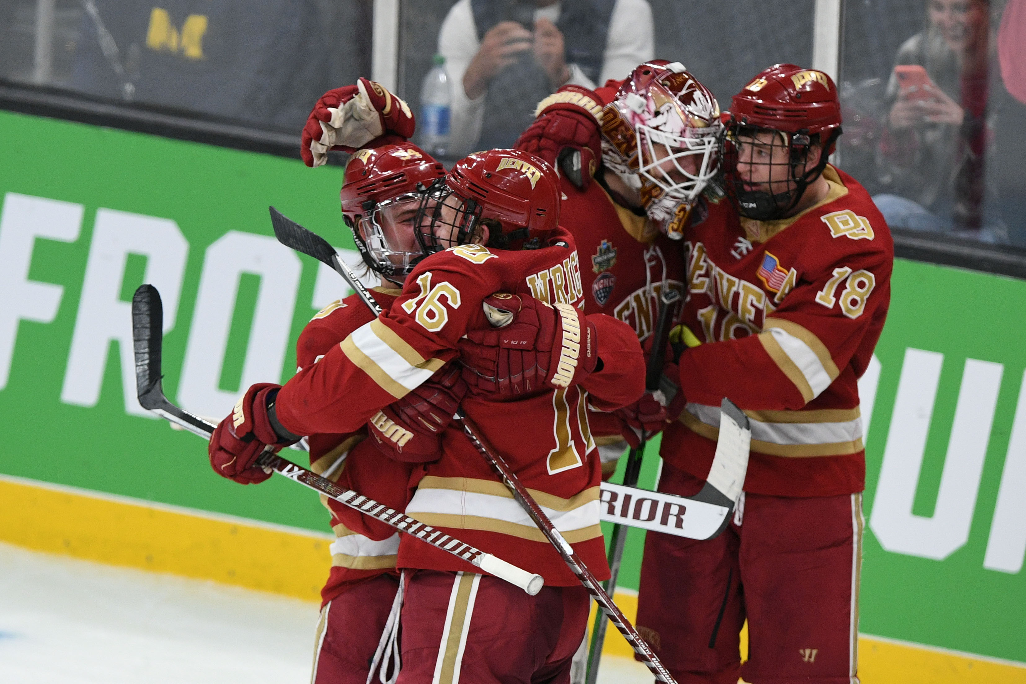 Denver Pioneers forward Bobby Brink celebrates with forward Cameron Wright after defeating Michigan Wolverines in an overtime period of the 2022 Frozen Four college ice hockey national semifinals at the TD Garden.