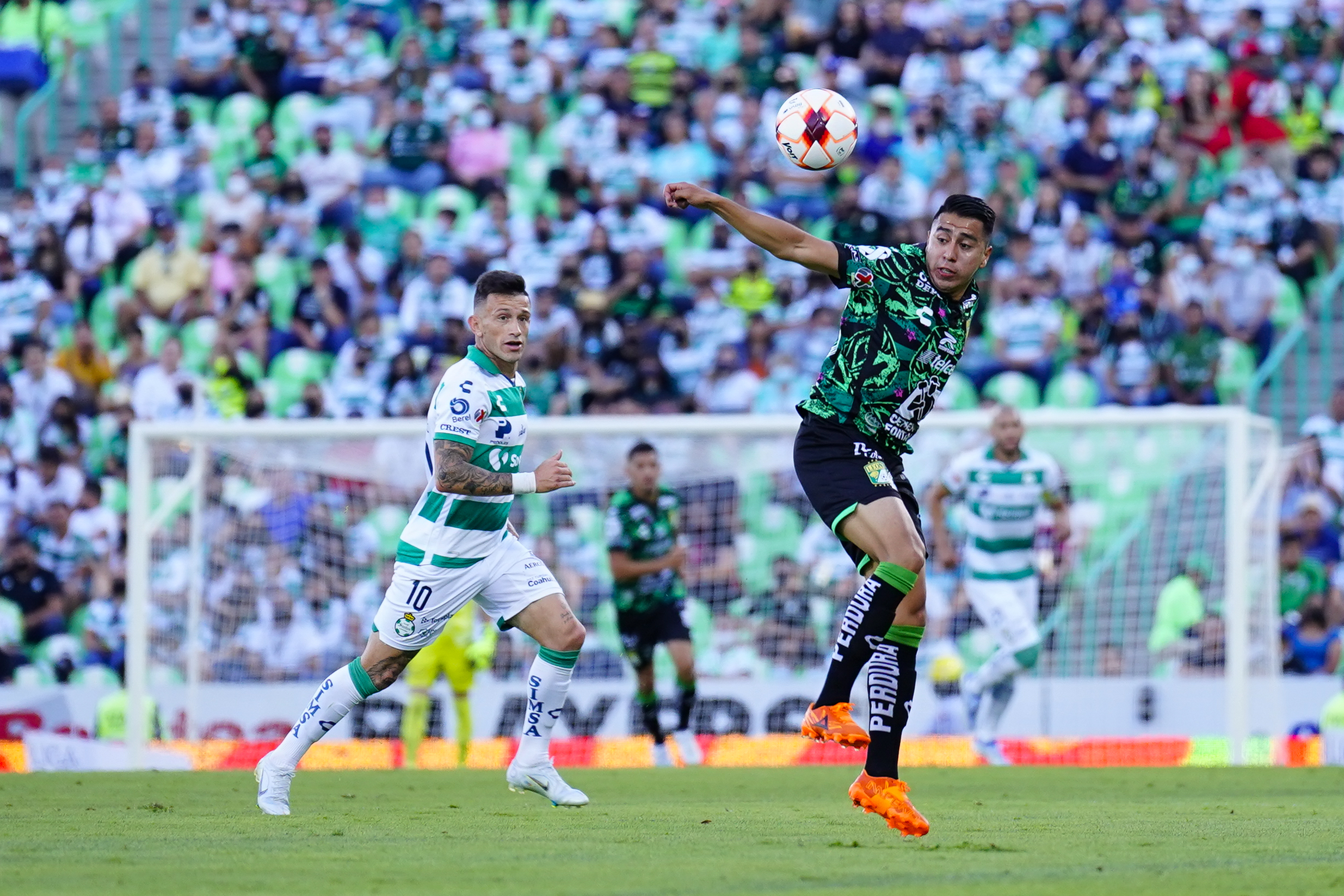 &nbsp;Brian Lozano (L) of Santos fights for the ball with Fidel Ambriz (R) of Leon during the 16th round match between Santos Laguna and Leon as part of the Torneo Grita Mexico C22 Liga MX at Corona Stadium on April 24, 2022 in Torreon, Mexico.