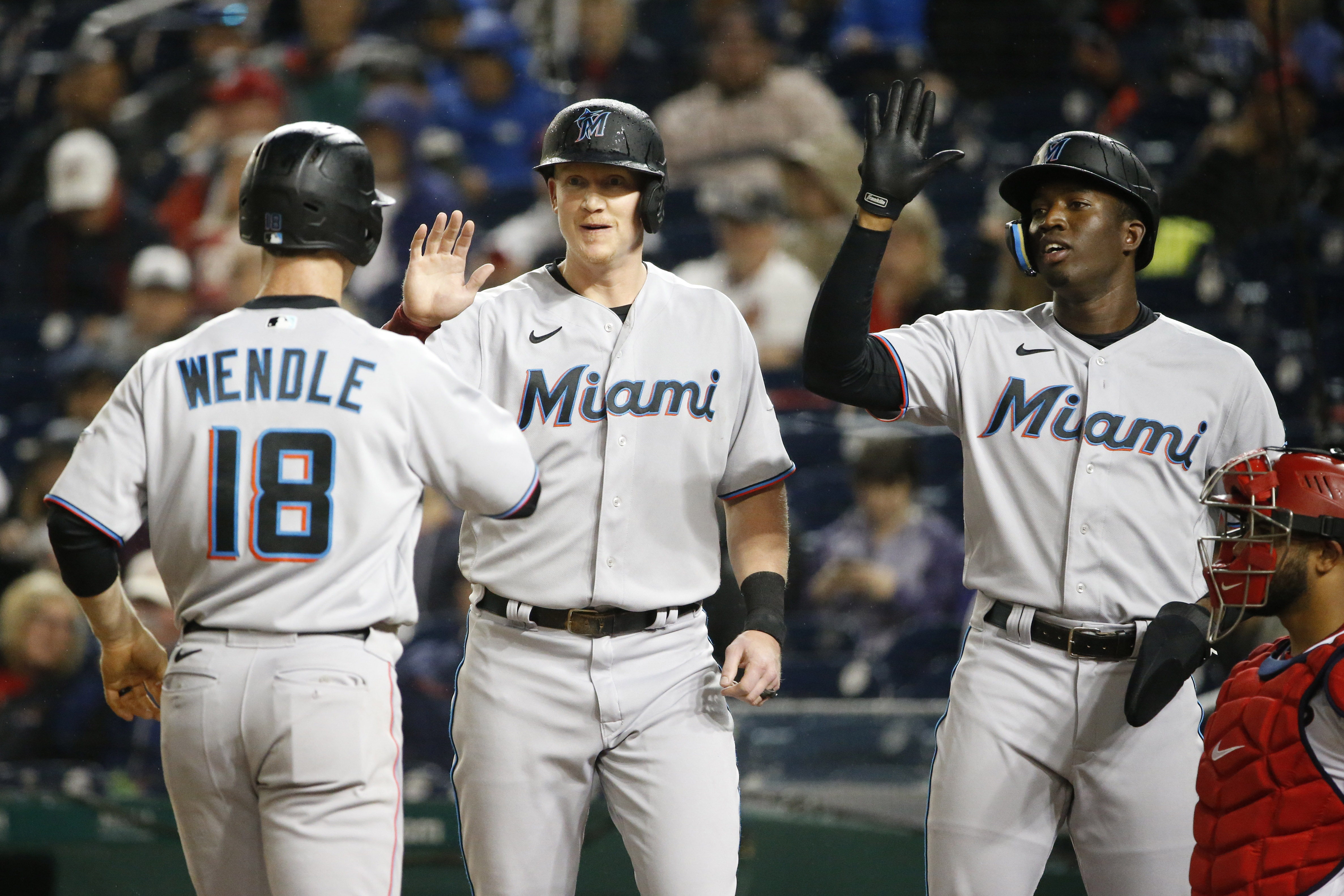 Miami Marlins shortstop Joey Wendle (18) celebrates with Marlins designated hitter Garrett Cooper (26) and Marlins center fielder Jesus Sanchez (7) at home plate after hitting a three run home run during the fourth inning against the Washington Nationals at Nationals Park.