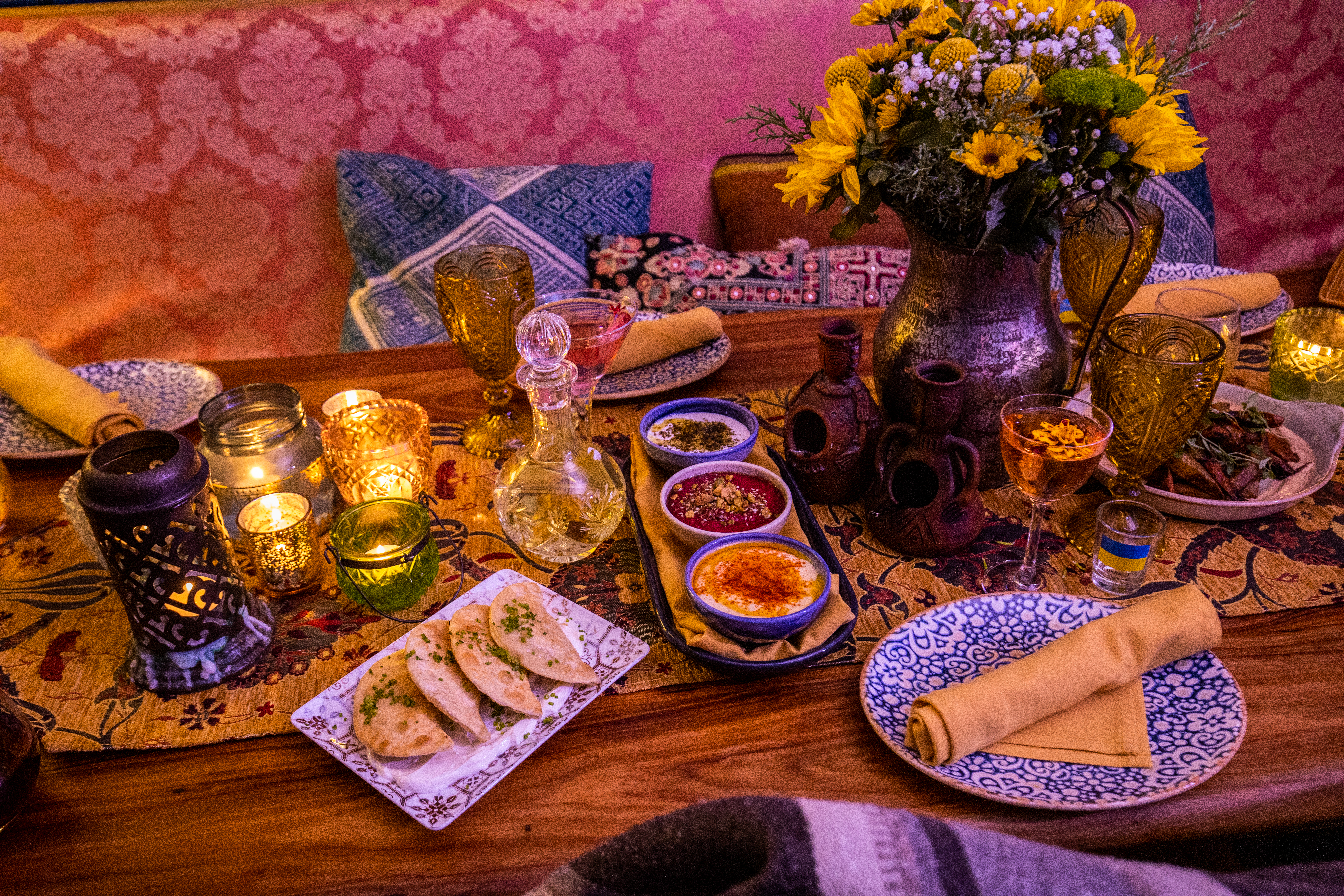 A spread of food on colorful plates on a wooden table