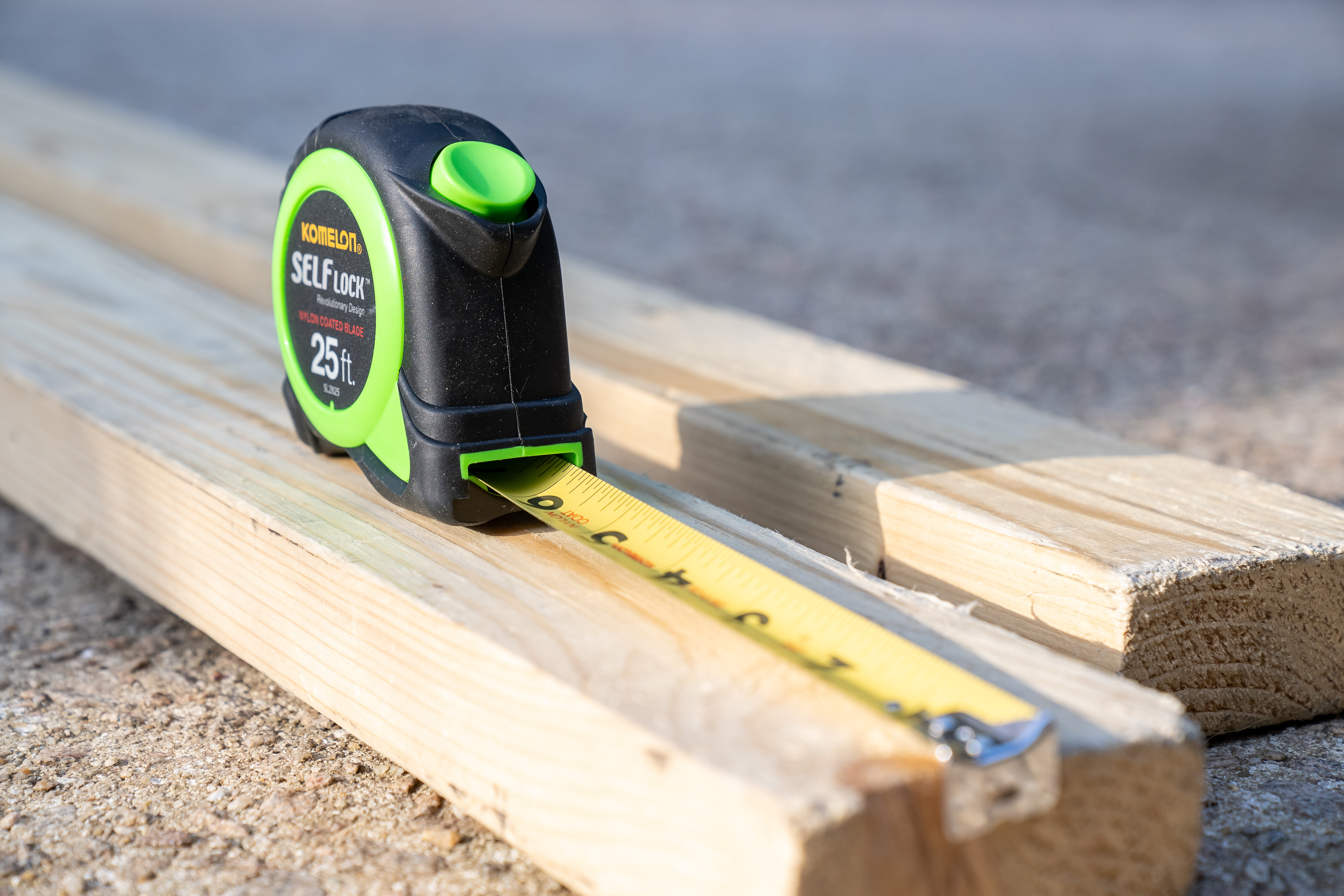 tape measure extended on a wood plank on the ground
