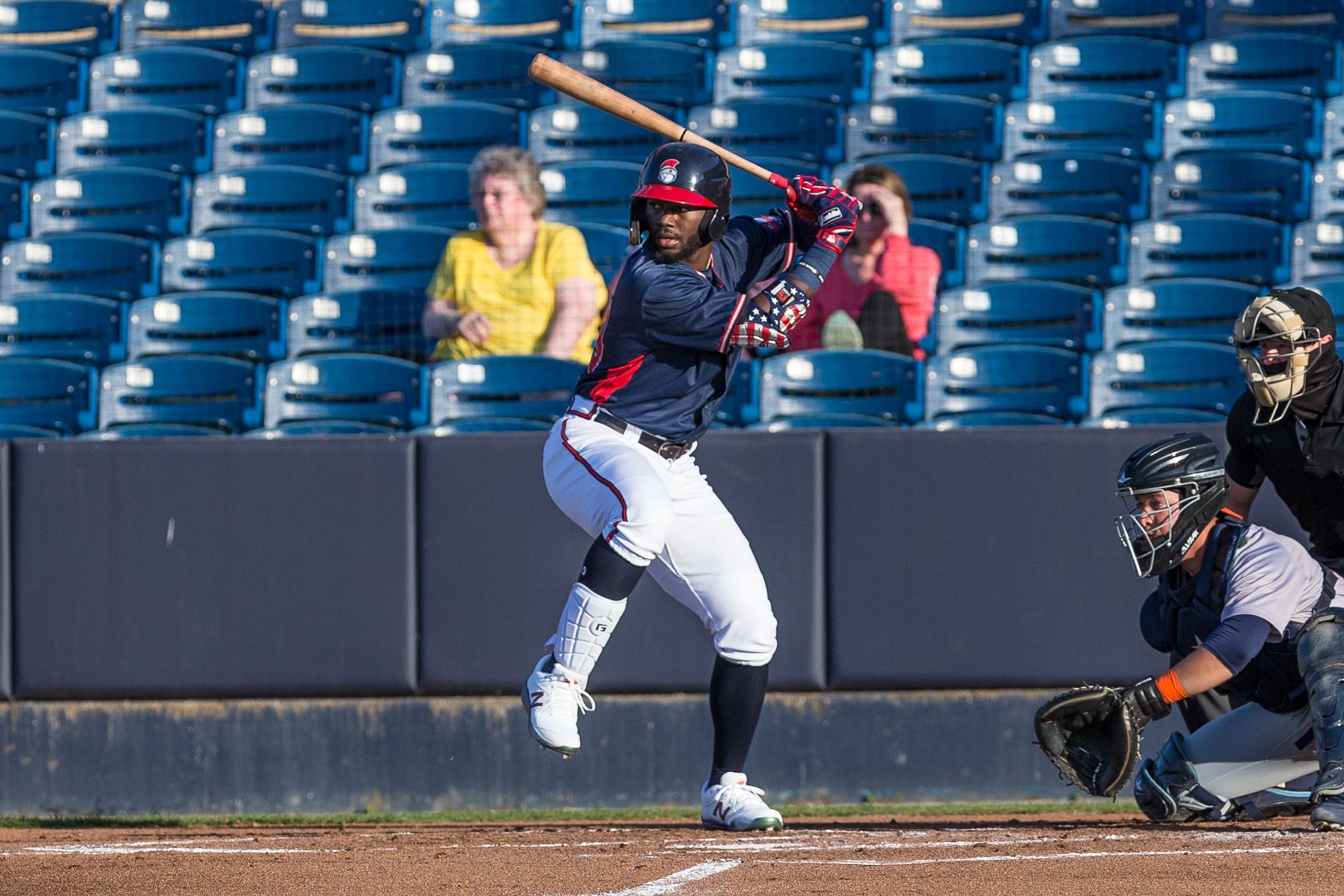 Michael Harris takes a swing for the Rome Braves during a day game. Camera is looking down the third base line at the left handed swinging Harris. Harris’s foot is lifted in anticipation of the pitch and the catcher has his glove out to receive the ball.