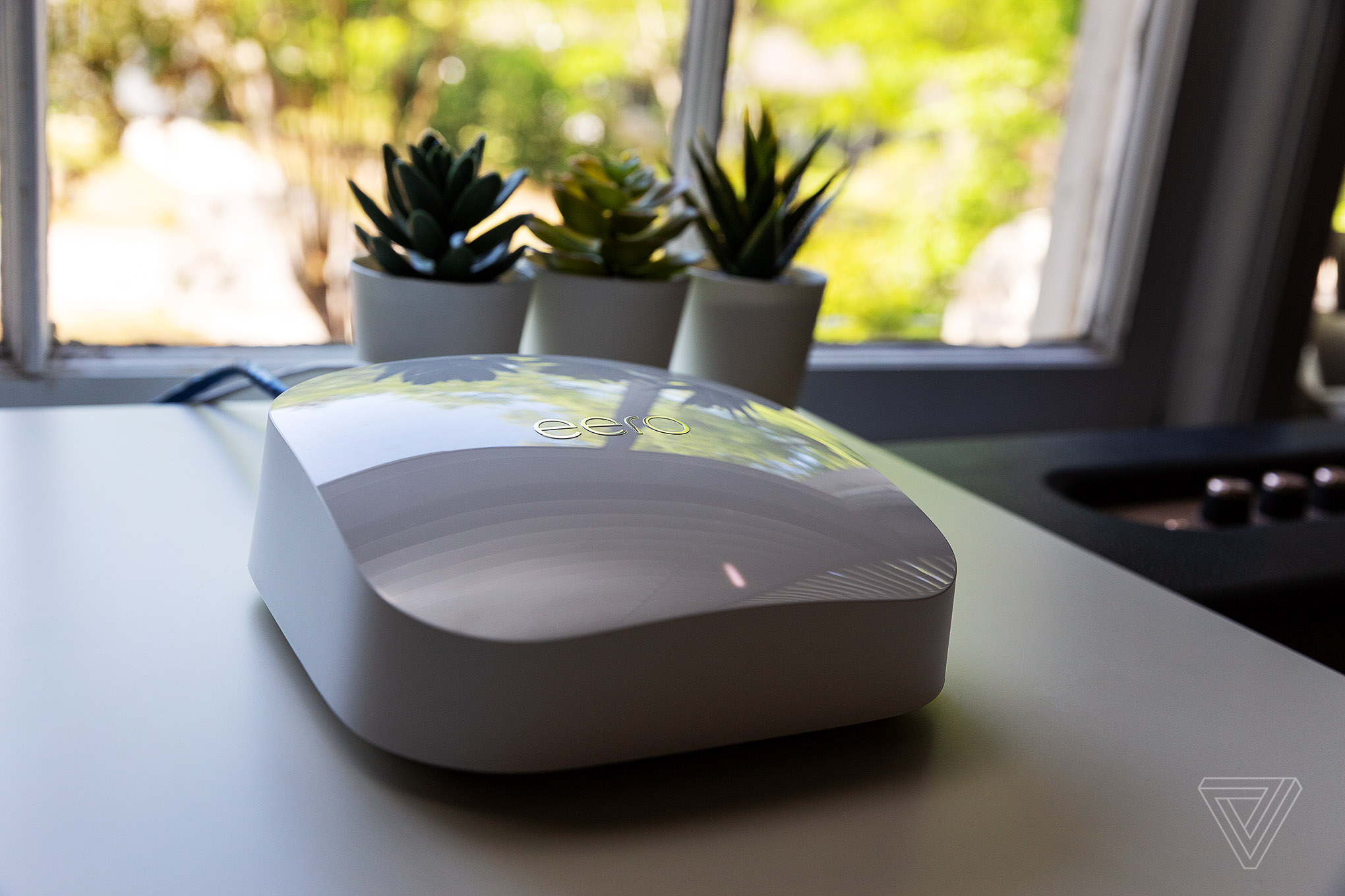 A close-up photo of the white Eero Pro 6E router, connected in a home.
