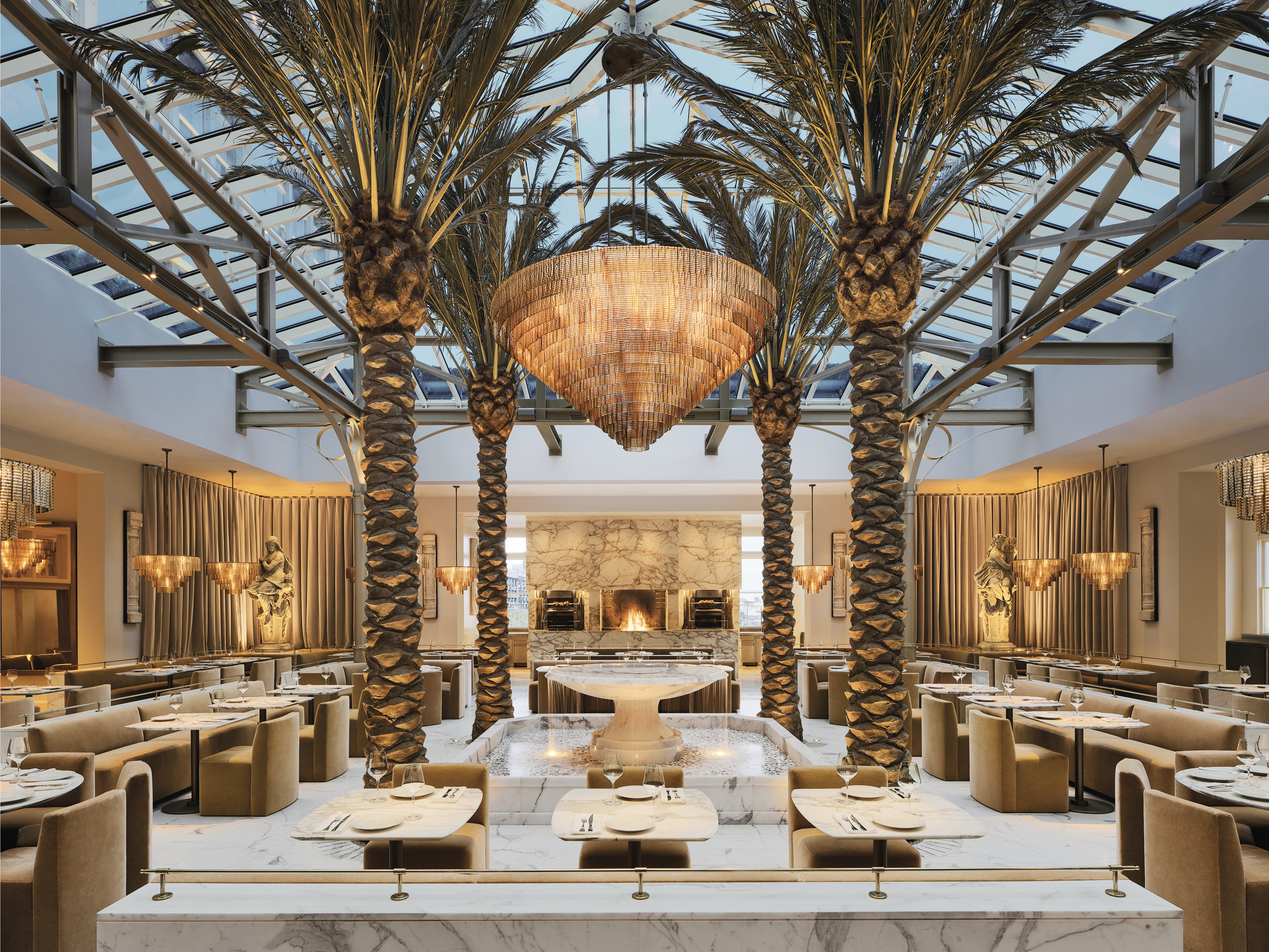 The Palm Court Restaurant including a fountain and four date palms in the center of the dining room.