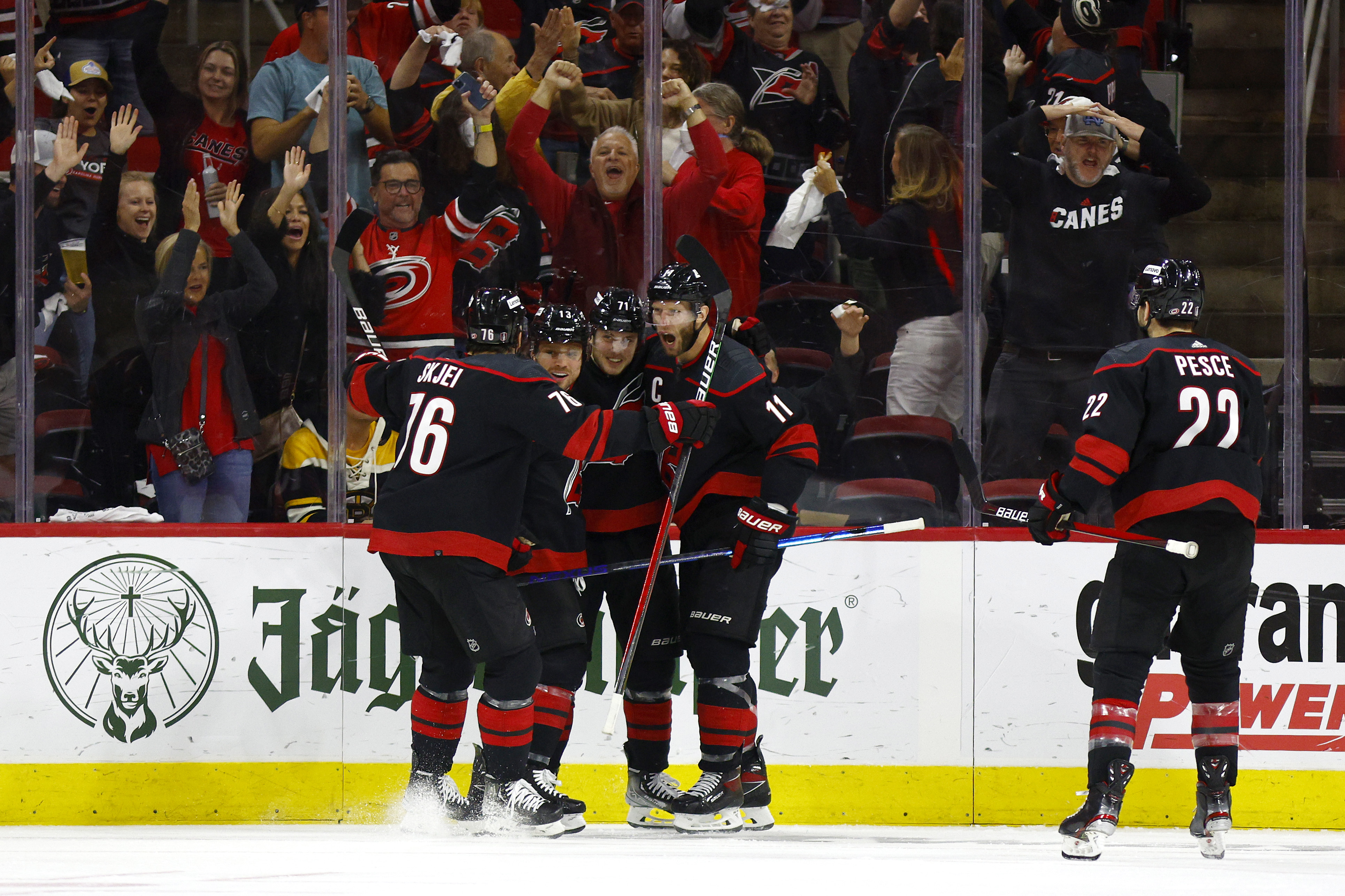 The Carolina Hurricanes celebrate with Max Domi #13 following his second period goal in Game Seven of the First Round of the 2022 Stanley Cup Playoffs against the Boston Bruins at PNC Arena on May 14, 2022 in Raleigh, North Carolina.