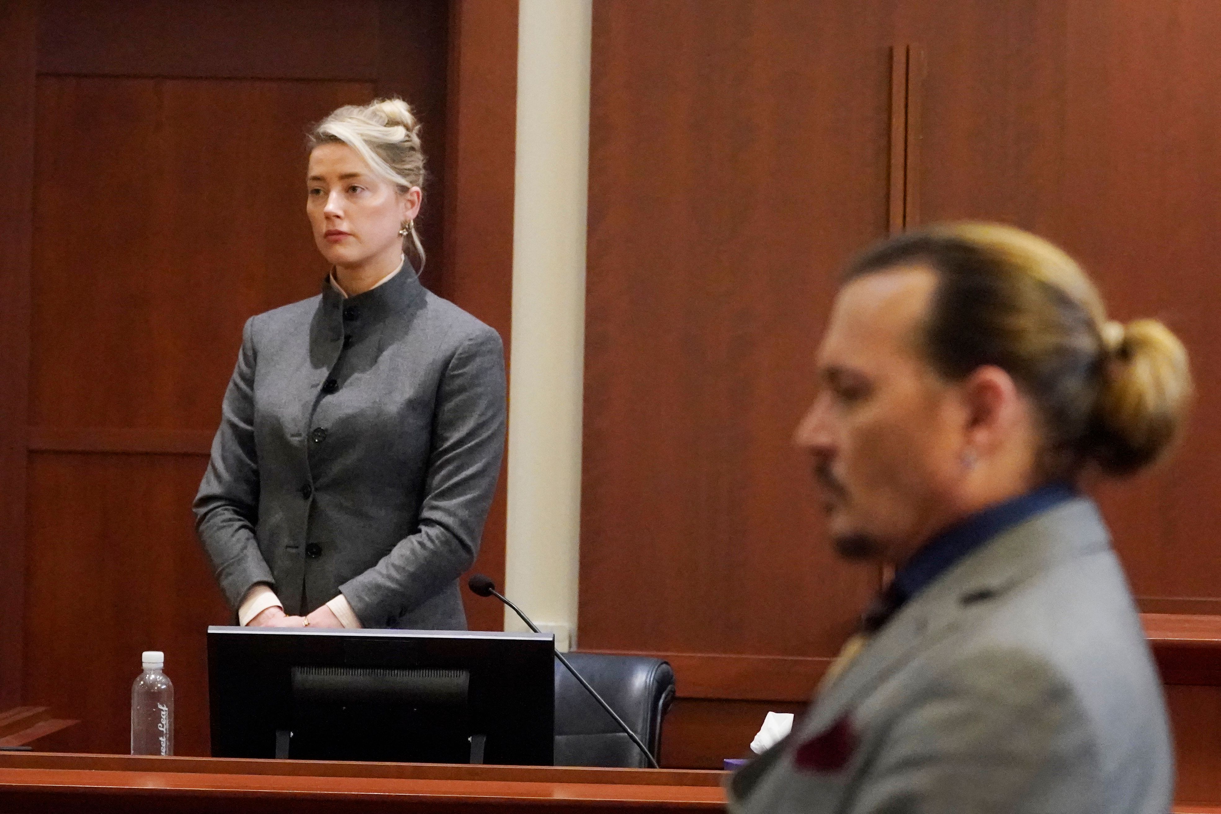 Amber Heard and Johnny Depp watch as the jury leaves the courtroom at the end of the day at the Fairfax County Circuit Courthouse in Fairfax, Virginia, May 16, 2022