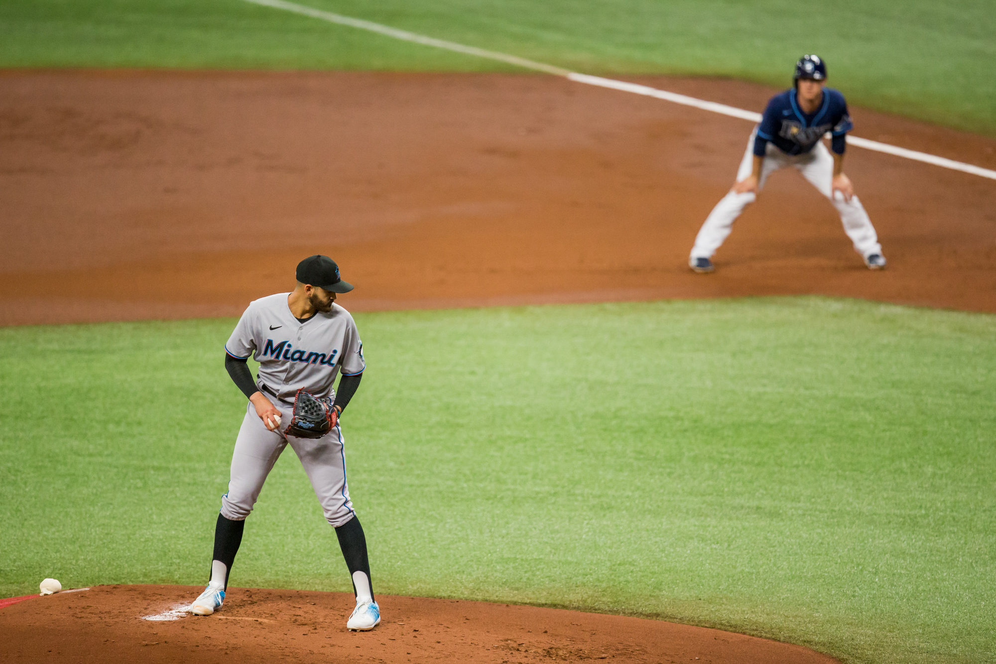 Miami Marlins starting pitcher Pablo Lopez (49) checks as Tampa Bay Rays third baseman Joey Wendle (18) leads off of first base during the first inning of a game at Tropicana Field.