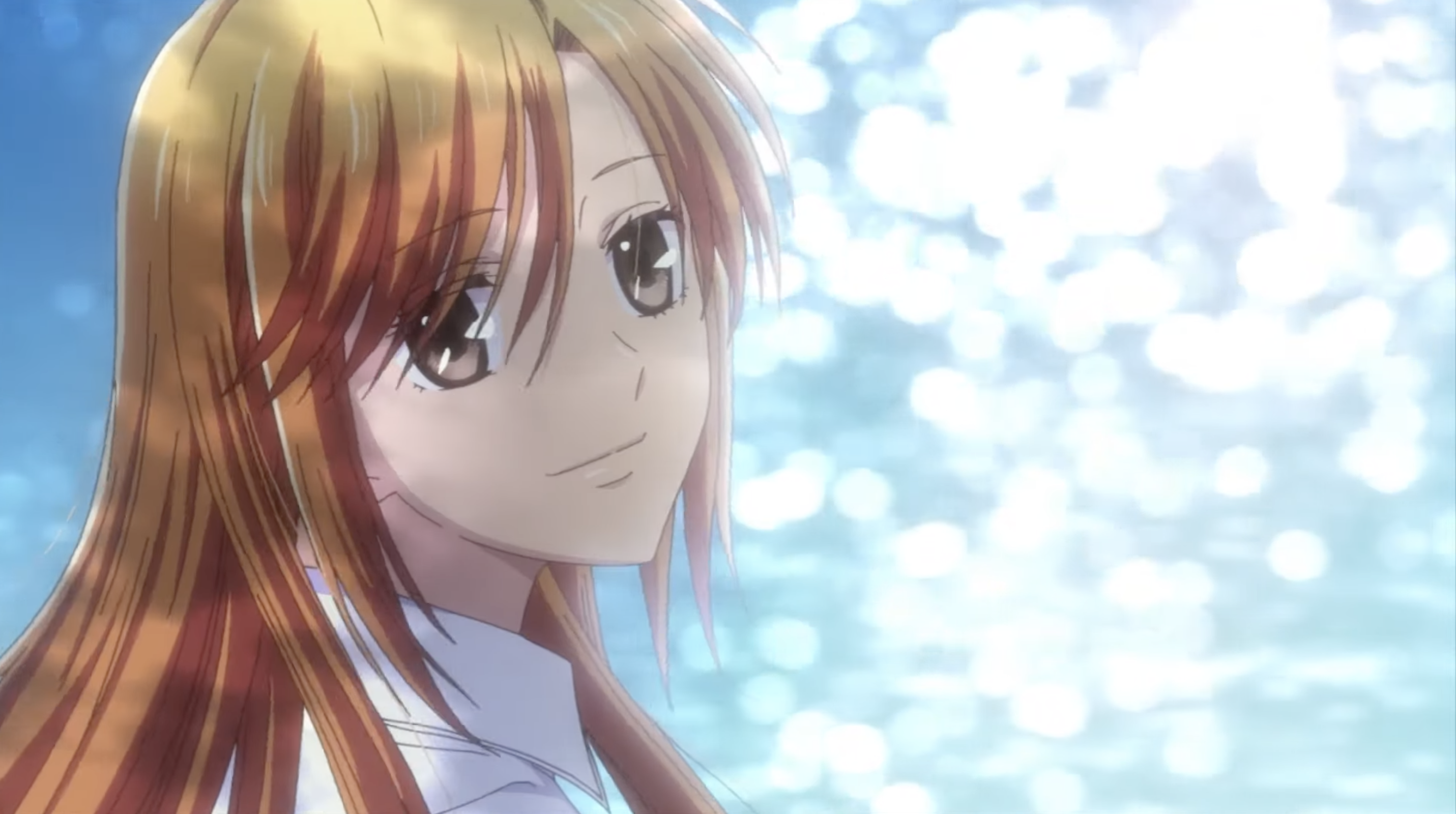 Kyoko Honda in Fruits Basket: Prelude. The light of the water is reflecting off her face and she has a soft smile as she looks into the camera.
