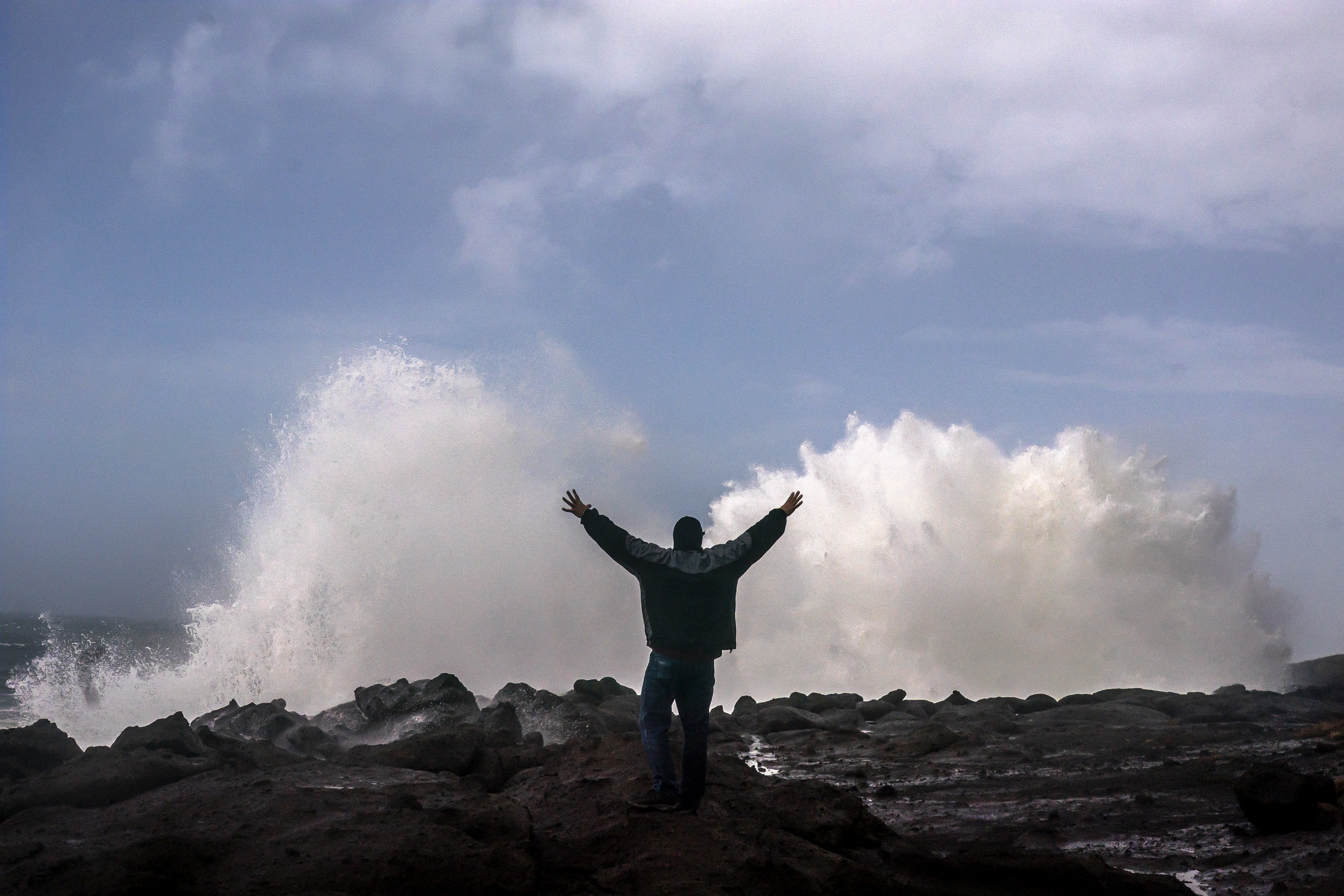 A man reacts as large waves caused by a bomb cyclone storm system break against the Oregon coast in Depoe Bay.